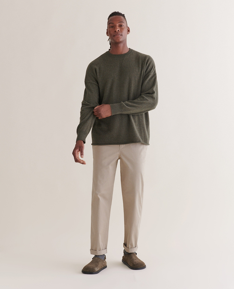 Image 1 of 5 showing man wearing Rise & Fall's finest cashmere mid-weight crew neck jumper in forest green with cream trousers.