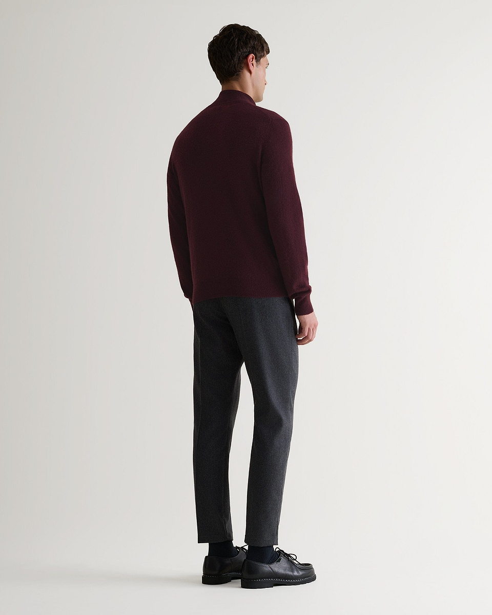 Image 2 of 6 showing man wearing Rise & Fall's fine cashmere 1/4 zip jumper, oxblood, back view.