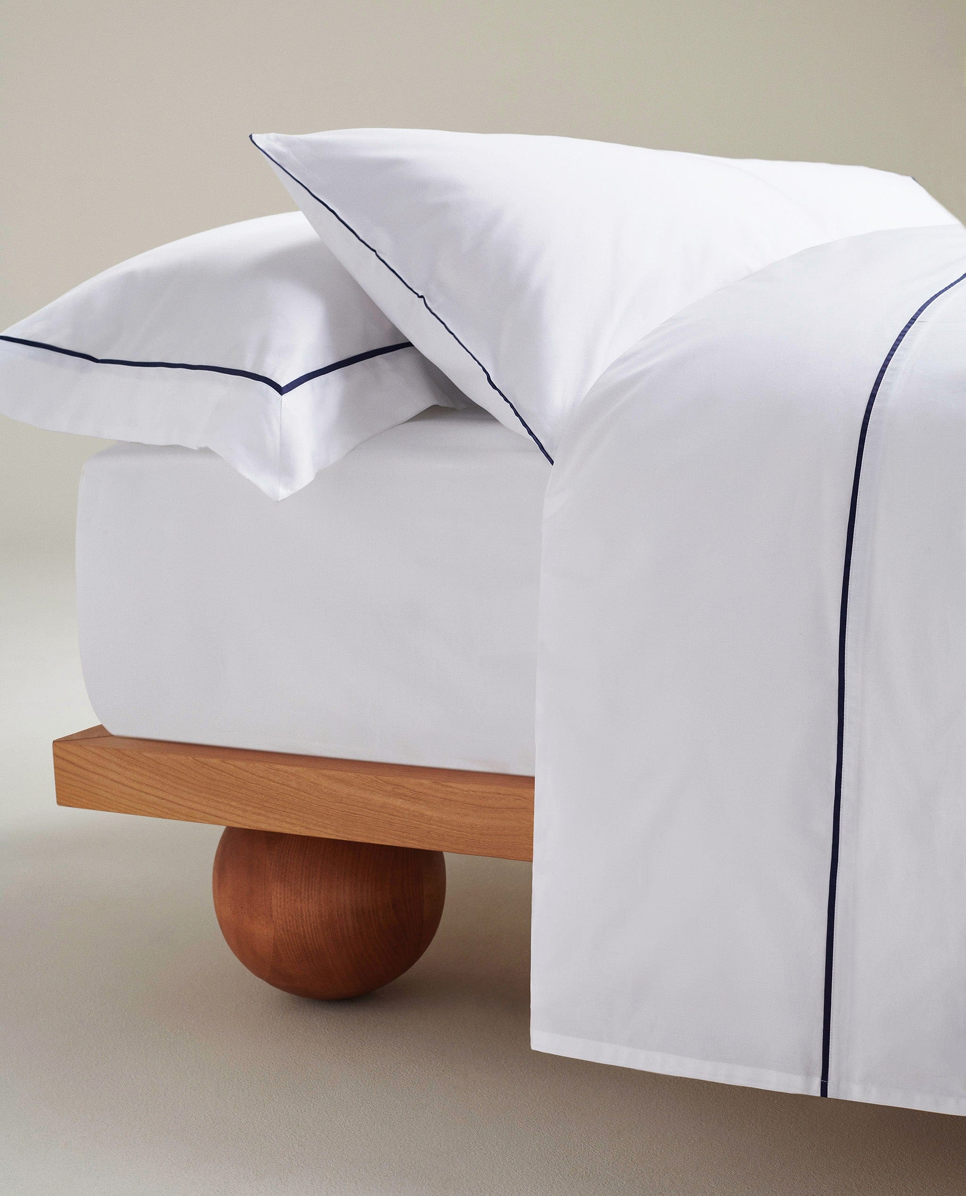 image 3 of 3 showing close up of bed with Rise & Fall's Crisp & Cool duvet set, colour: white navy piping, fabric: percale cotton