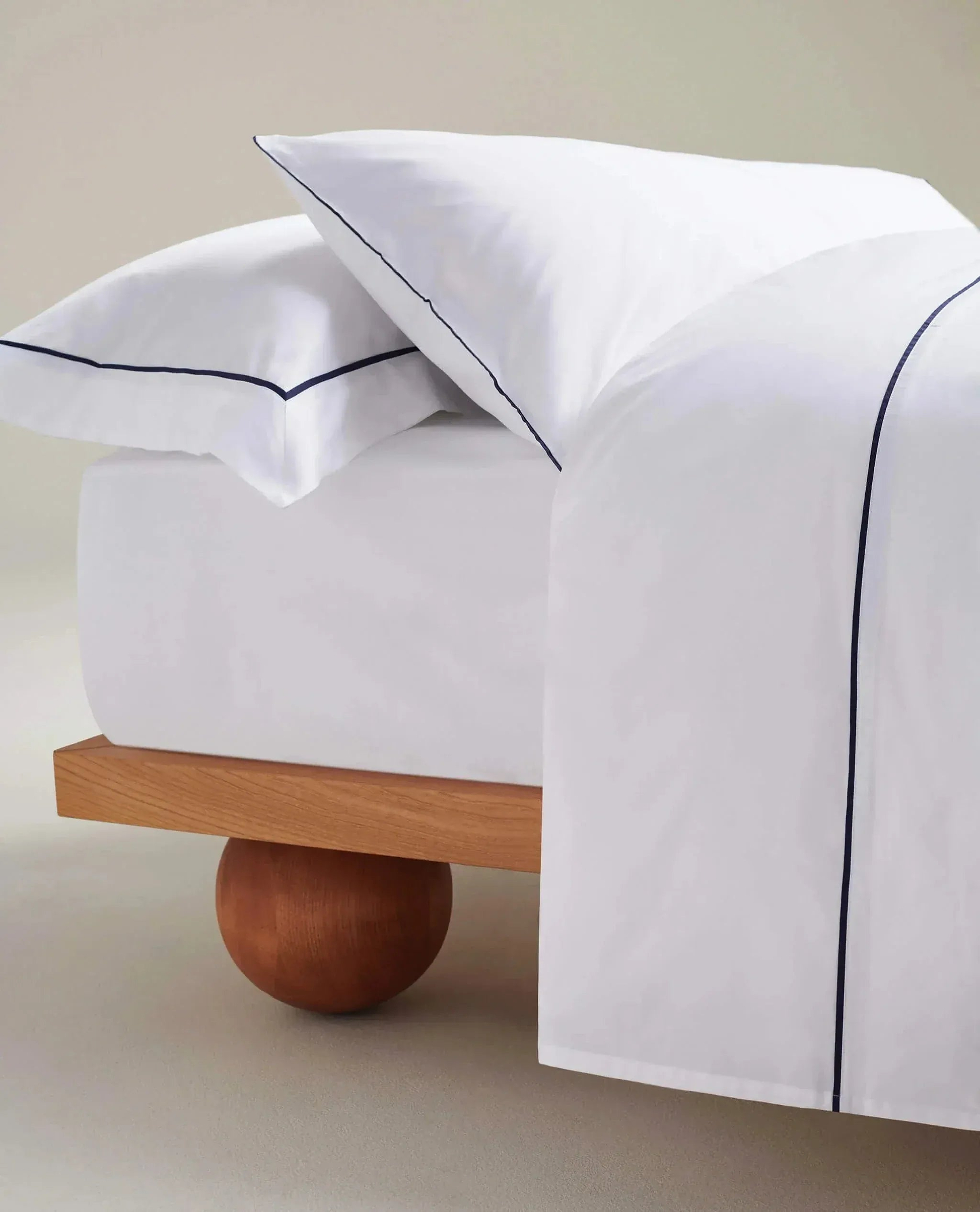 Imge 3 of 4 showing Rise & Fall's Soft & Smooth organic sateen cotton flat sheet in white navy piping. 