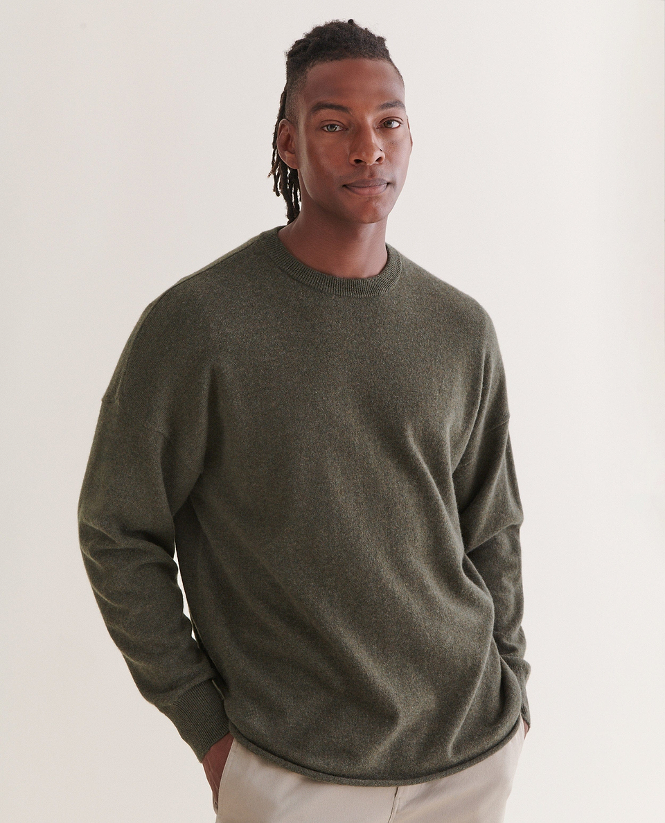 Image 3 of 5 showing man wearing Rise & Fall's finest cashmere mid-weight crew neck jumper in forest green with cream trousers.