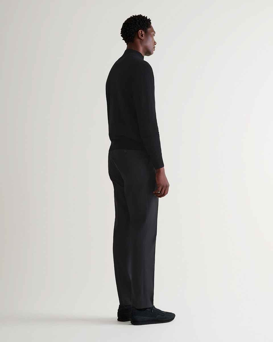 Image 3 of 5 showing man wearing Rise & Fall's fine cashmere 1/4 zip jumper, black.