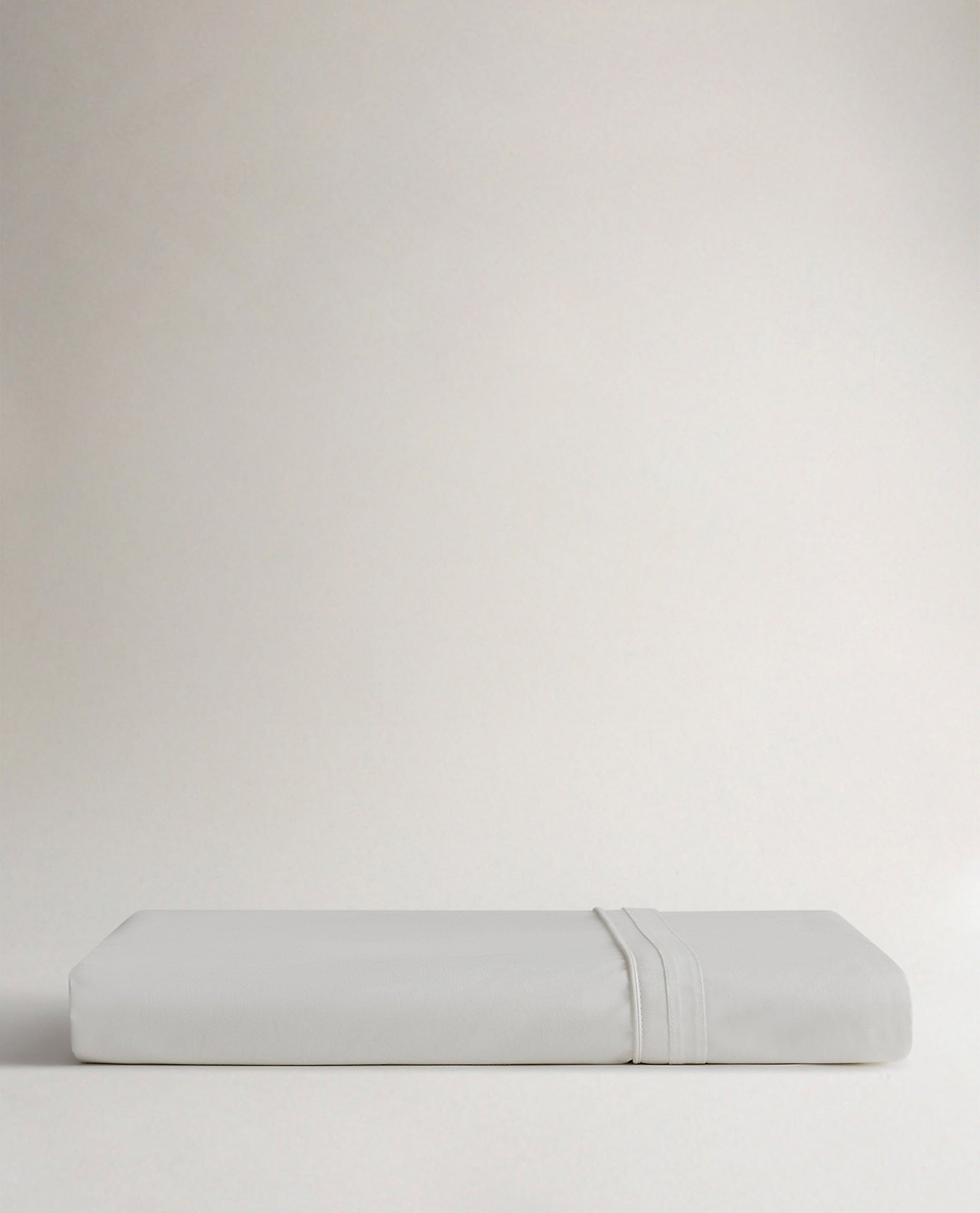 Image 3 of 5 showing Rise & Fall's Crisp & Cool organic percale cotton flat bed sheet in white tailored border.