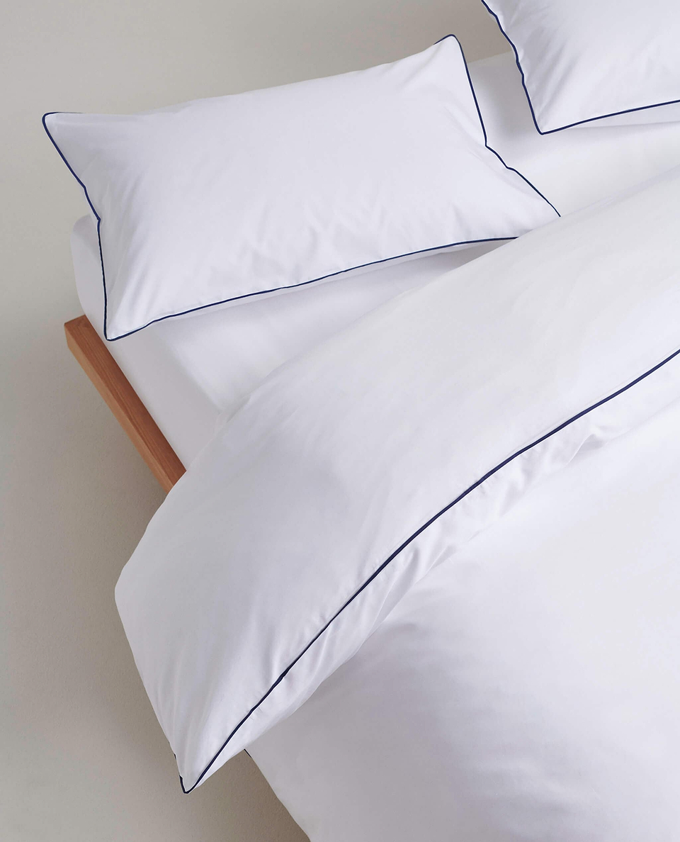 Image 3 of 5 showing Rise & Fall's Soft & Smooth Cotton Sateen Oxford Pillowcase Set in white navy piping.