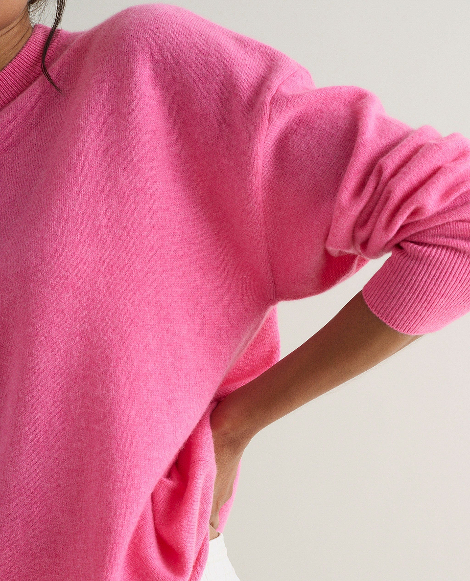 Image 4 of 4 showing close up of a woman wearing Rise & Fall's pink fine cashmere sweatshirt.
