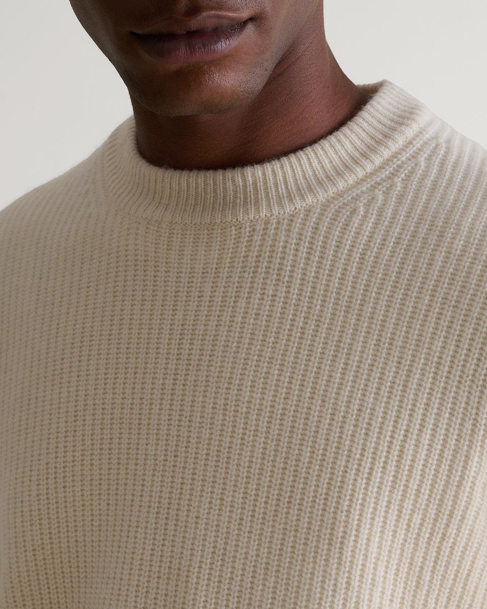 Image 4 of 5 showing close up of man wearing Rise & Fall's Cashmere Merino Fishermans Rib Crew Neck Jumper in cream.