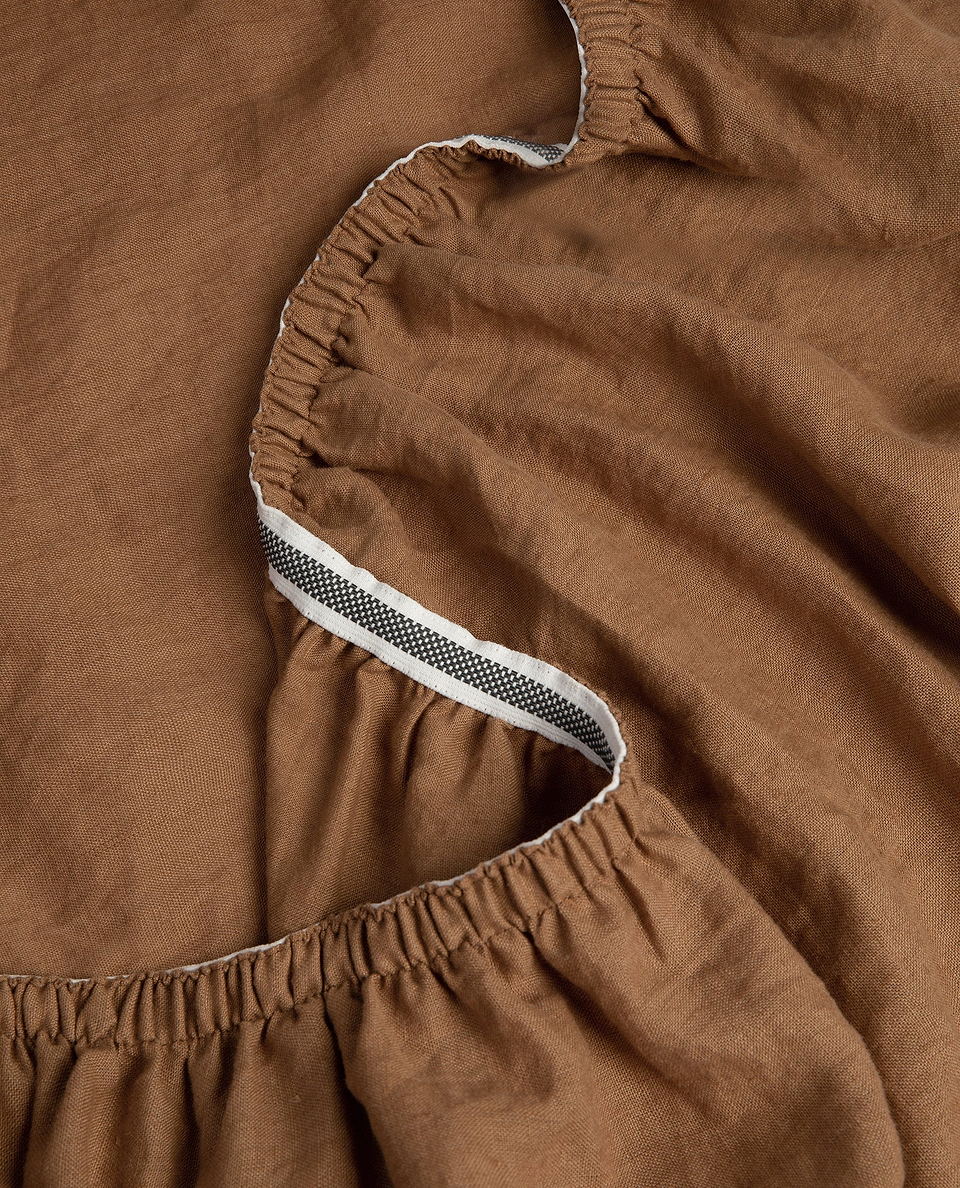 Image 4 of 5 showing Rise & Fall's Relaxed & Refined European flax™ linen fitted sheet in ochre.
