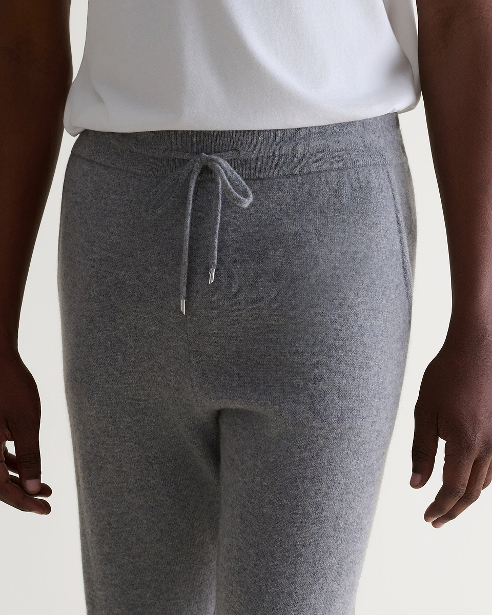 Image 5 of 6 showing man wearing Rise & Fall's fine cashmere joggers, grey, close up.