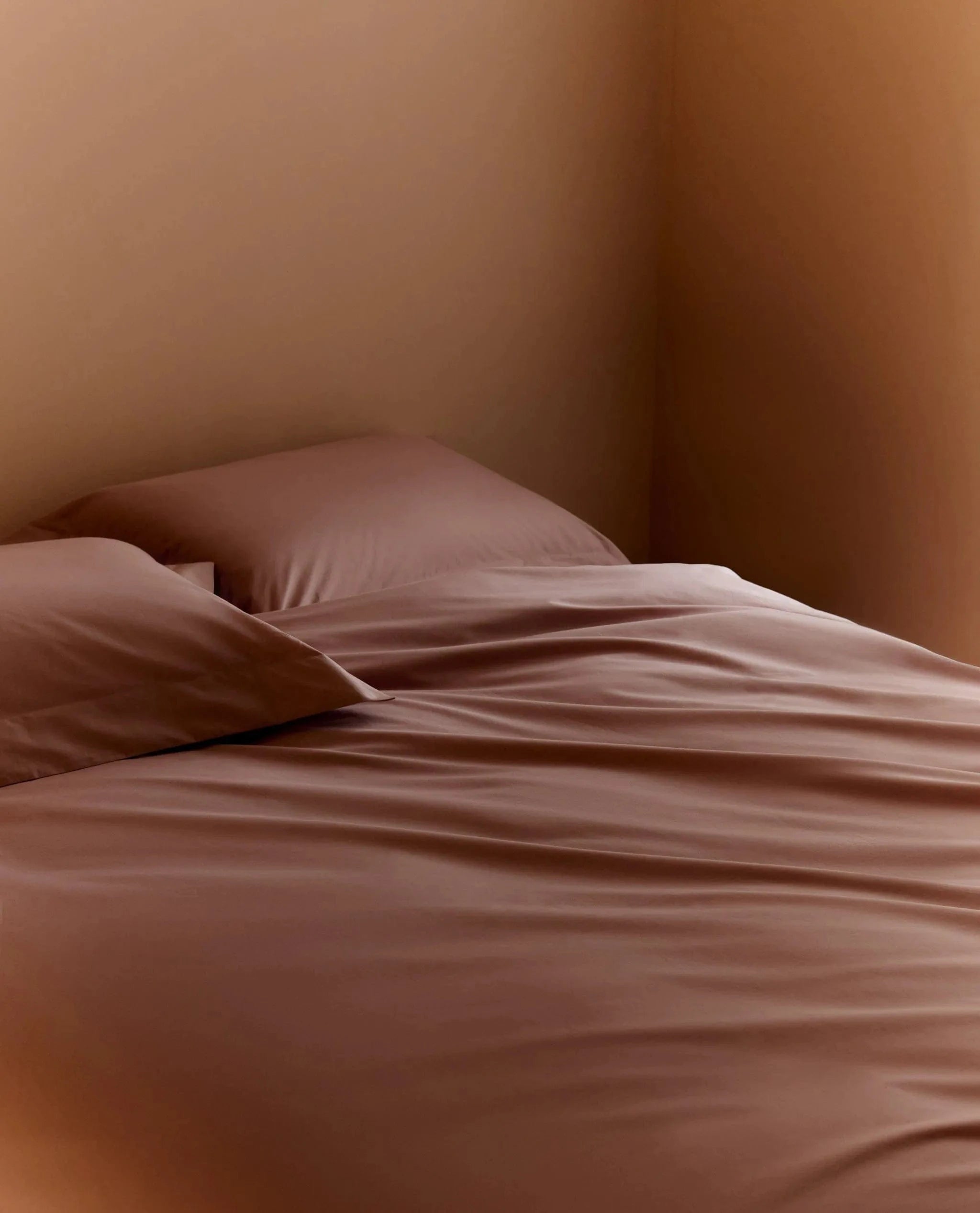 Image 6 of 6 showing bed made with Rise & Fall's Crisp & Cool organic cotton duvet set in clay.