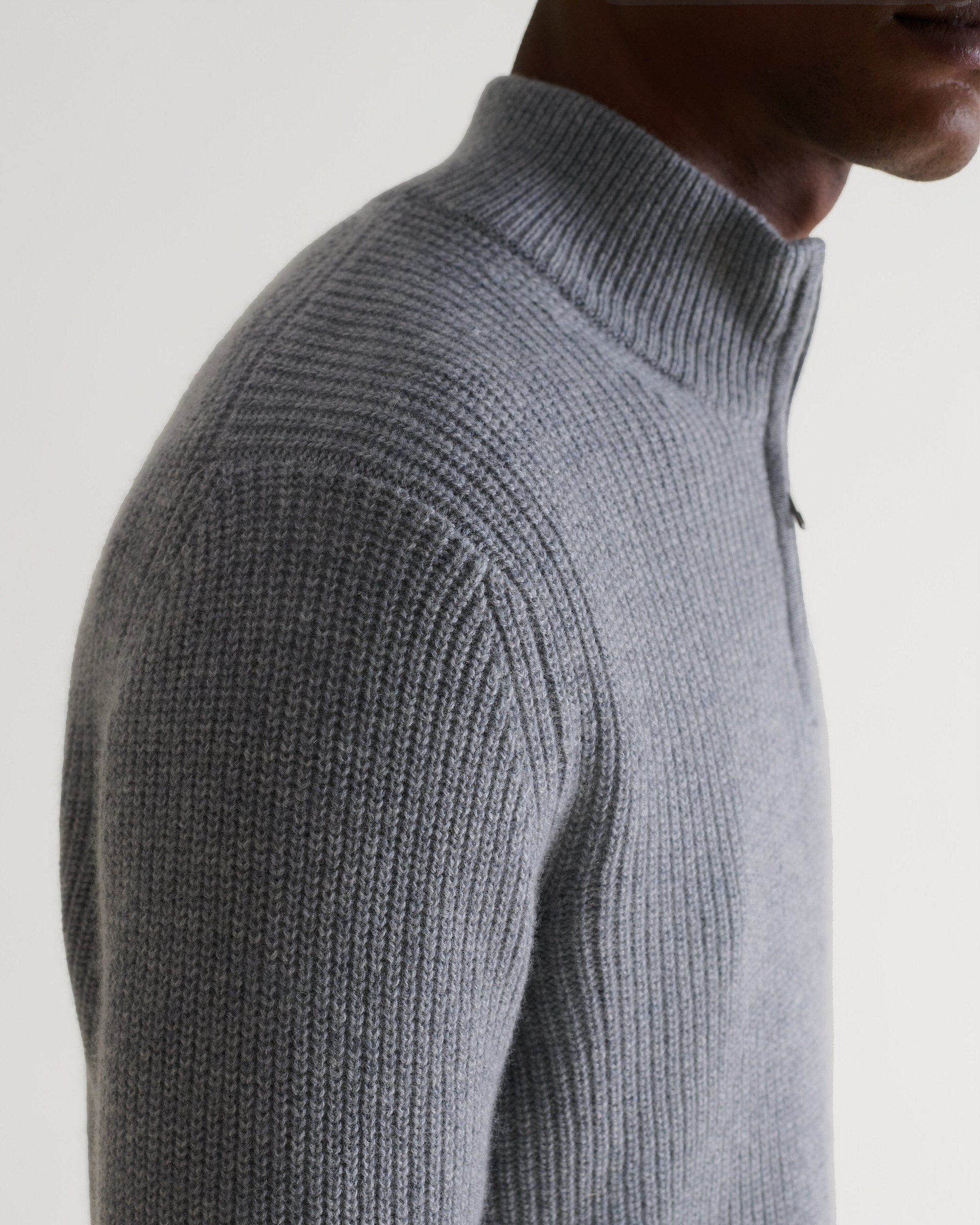 Image 6 of 6 showing cose up of man wearing Rise & Fall's Cashmere Merino Fishermans Rib 1/4 Zip Jumper in grey.