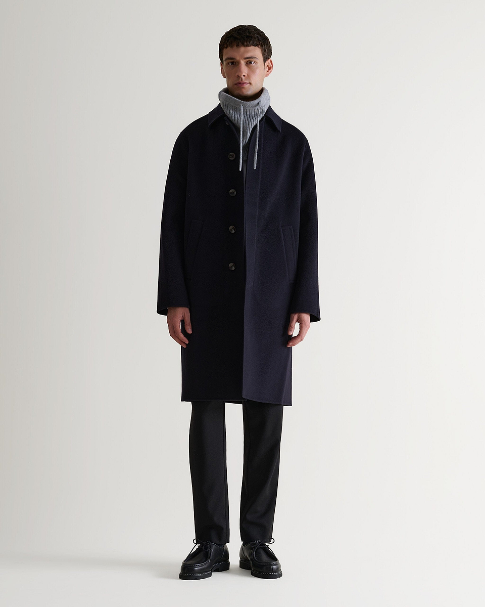 Full portrait of man wearing grey cashmere merino drawstring snood with navy wool coat