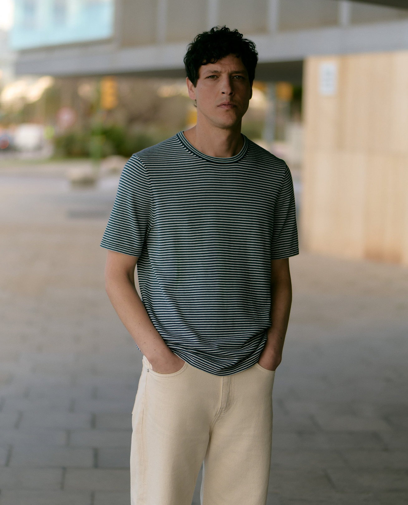 Man wearing silk-cotton fine knit stripe t-shirt.