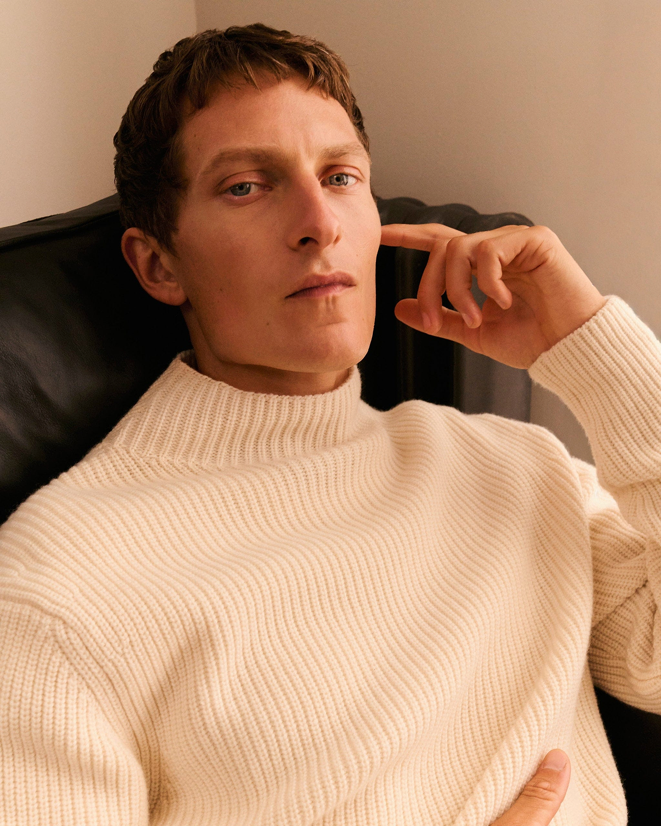 Man wears Rise & Fall's cream cashmere merino jumper.