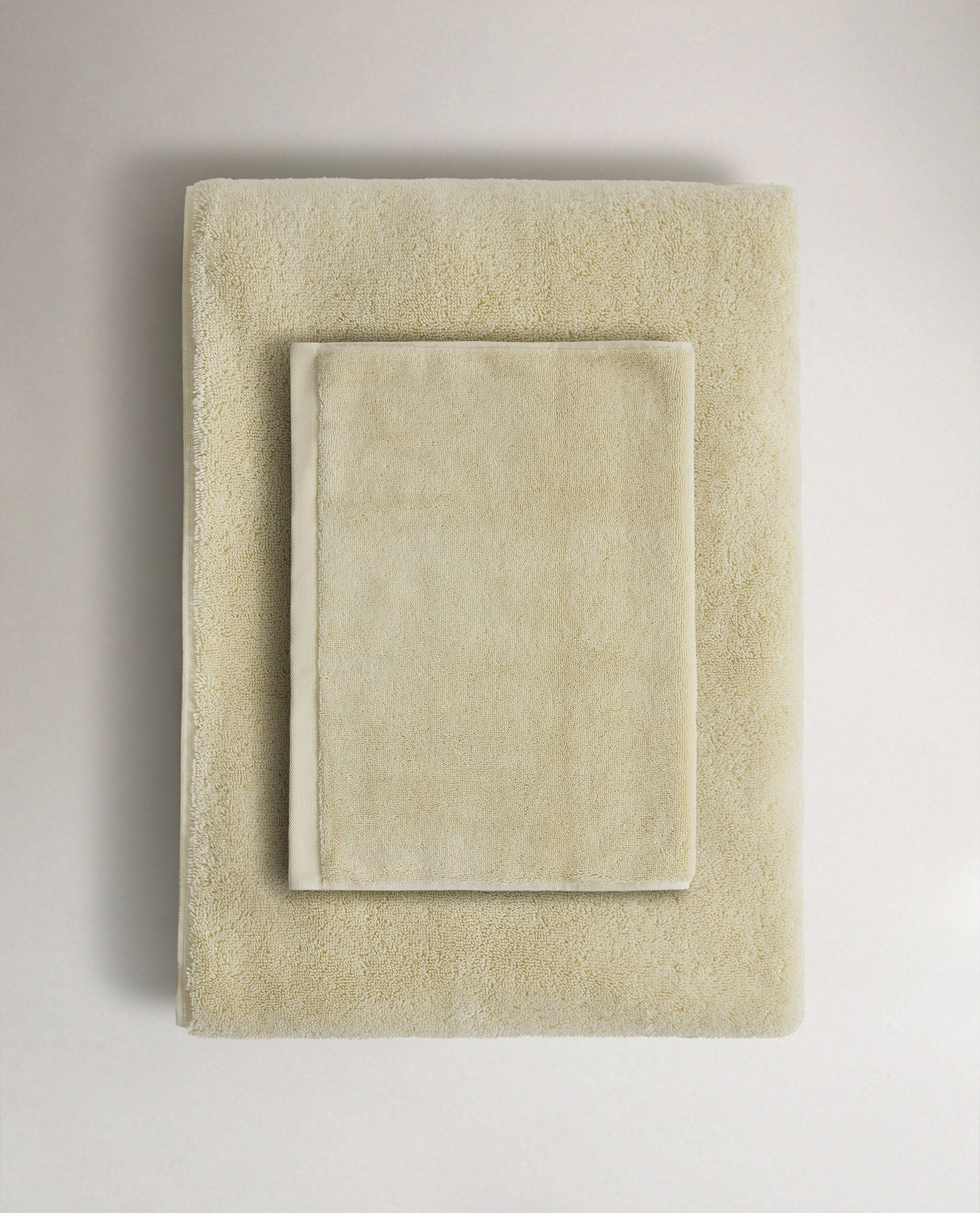 Rise & Fall's buttermilk Turkish cotton hand towel lying on top of matching bath towel