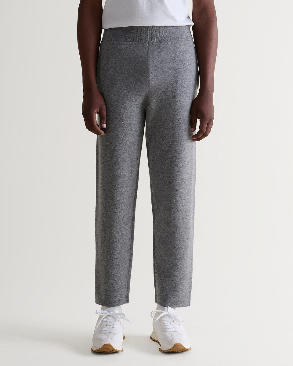 Close up of Rise & Fall's grey cashmere merino double-faced joggers with white T-shirt and trainers. 