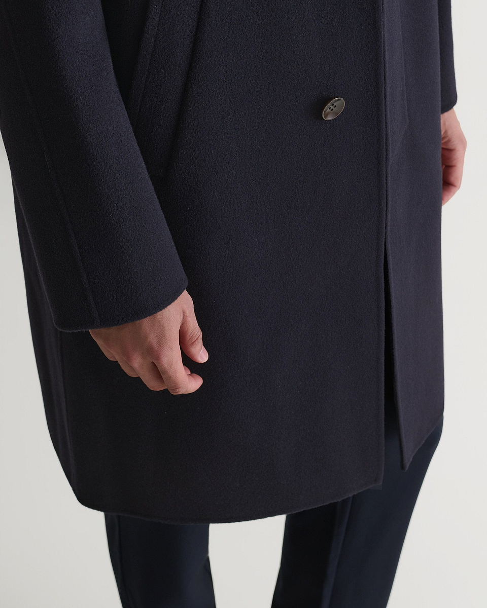 Rise & Fall's navy cashmere merino wool double-faced coat. Close up of bottom front edge.
