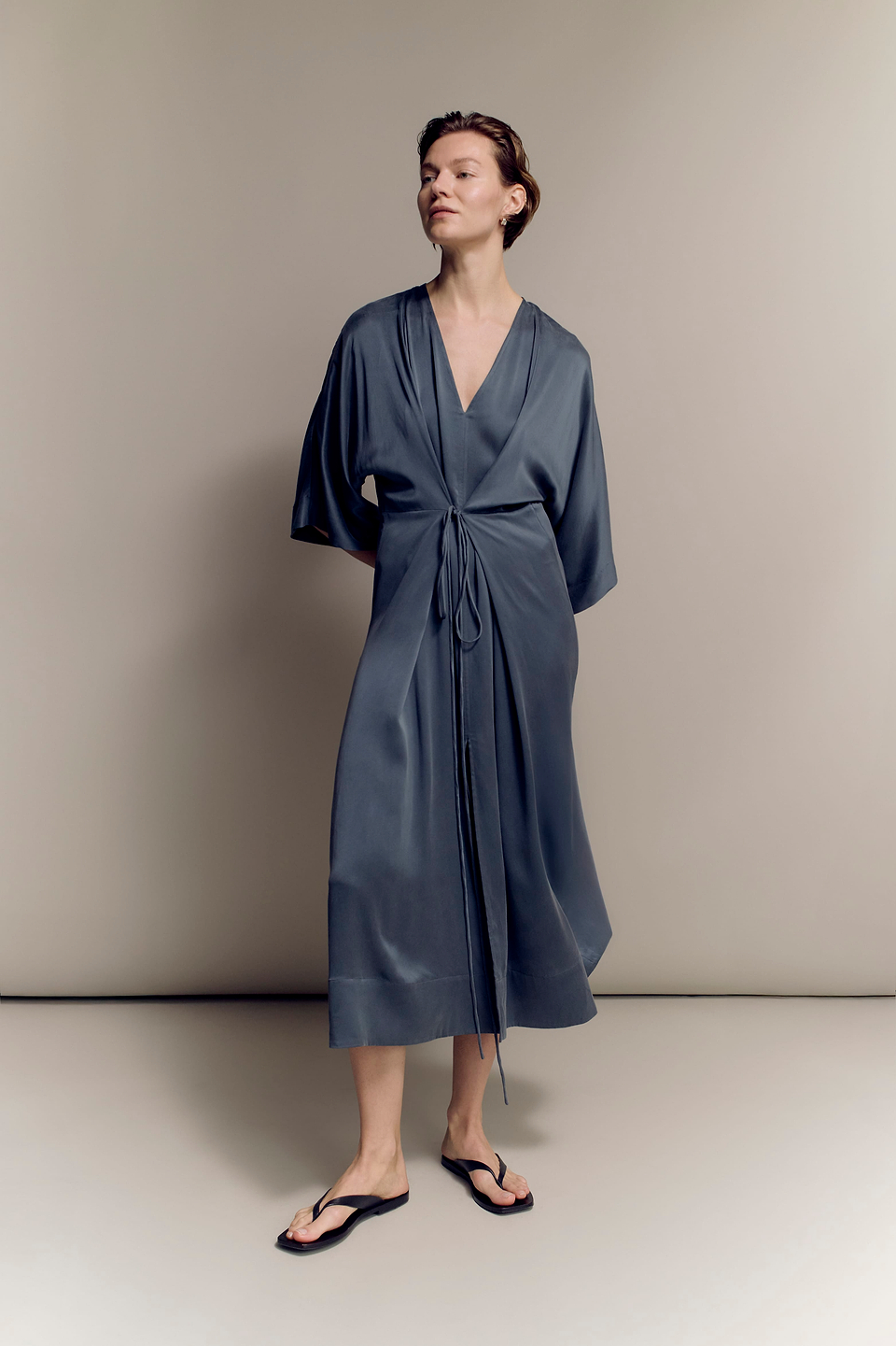 Woman wears Rise & Fall's Silk Organza Layered Maxi Dress in Moonlake blue.