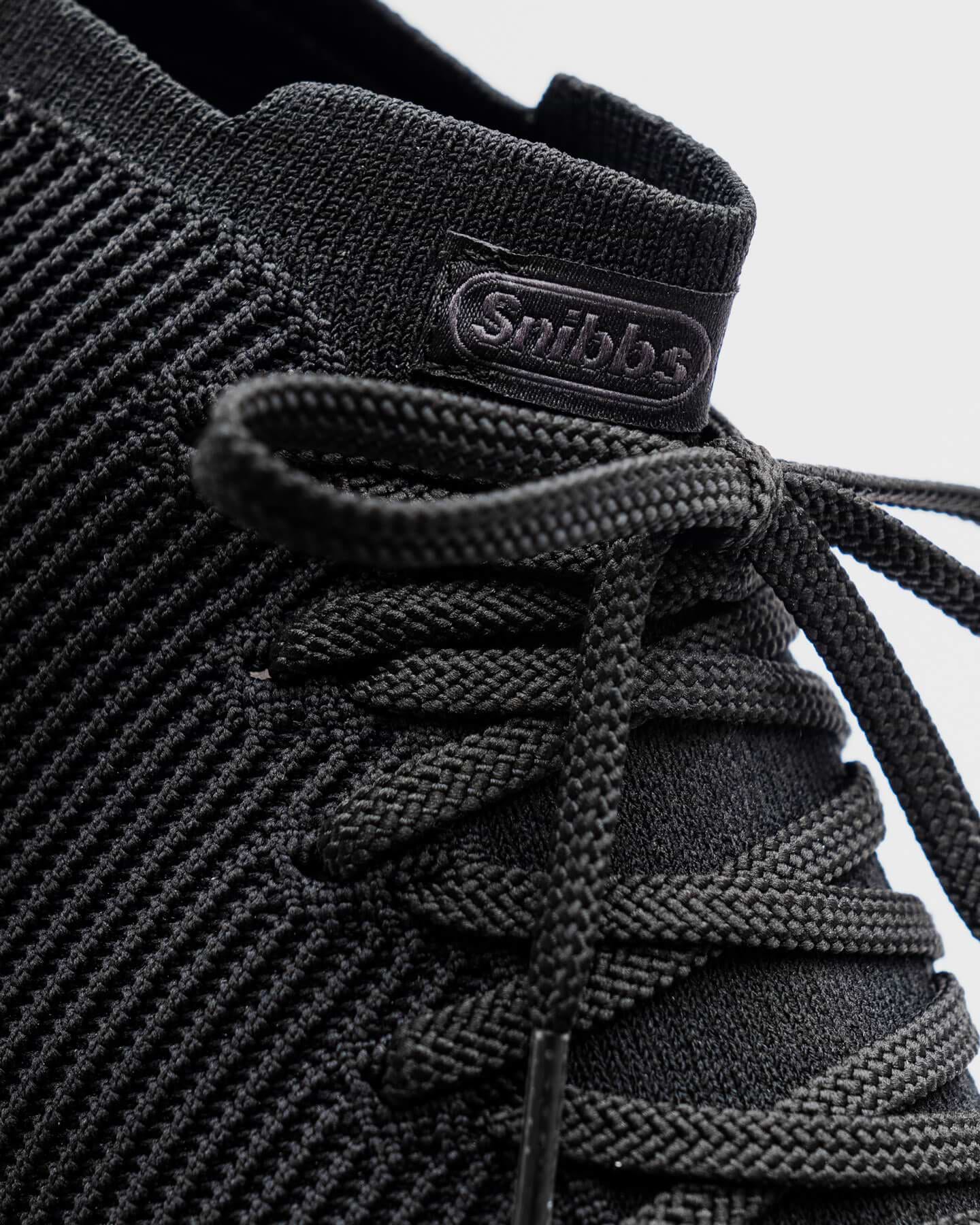 Close-up of the Snibbs ROVR Mid - Eclipse Black (VN) sneaker with slip-resistant sole, shown on a light background.