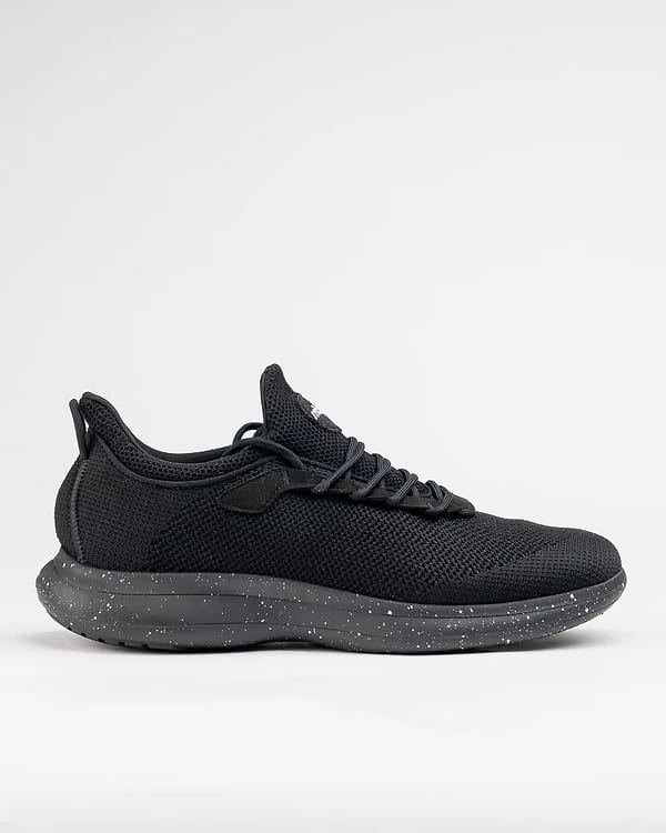 The Snibbs Orbit - Black Speckle: a black athletic shoe with a speckled sole, breathable knit upper, and slip-resistant design, side view.