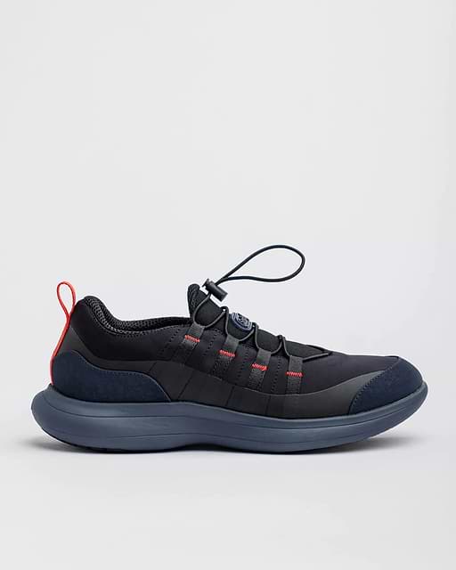 The Snibbs Orbit SE H&B - Illy, a black athletic shoe with red, blue sole, speed laces, is shown in profile on a white background.
