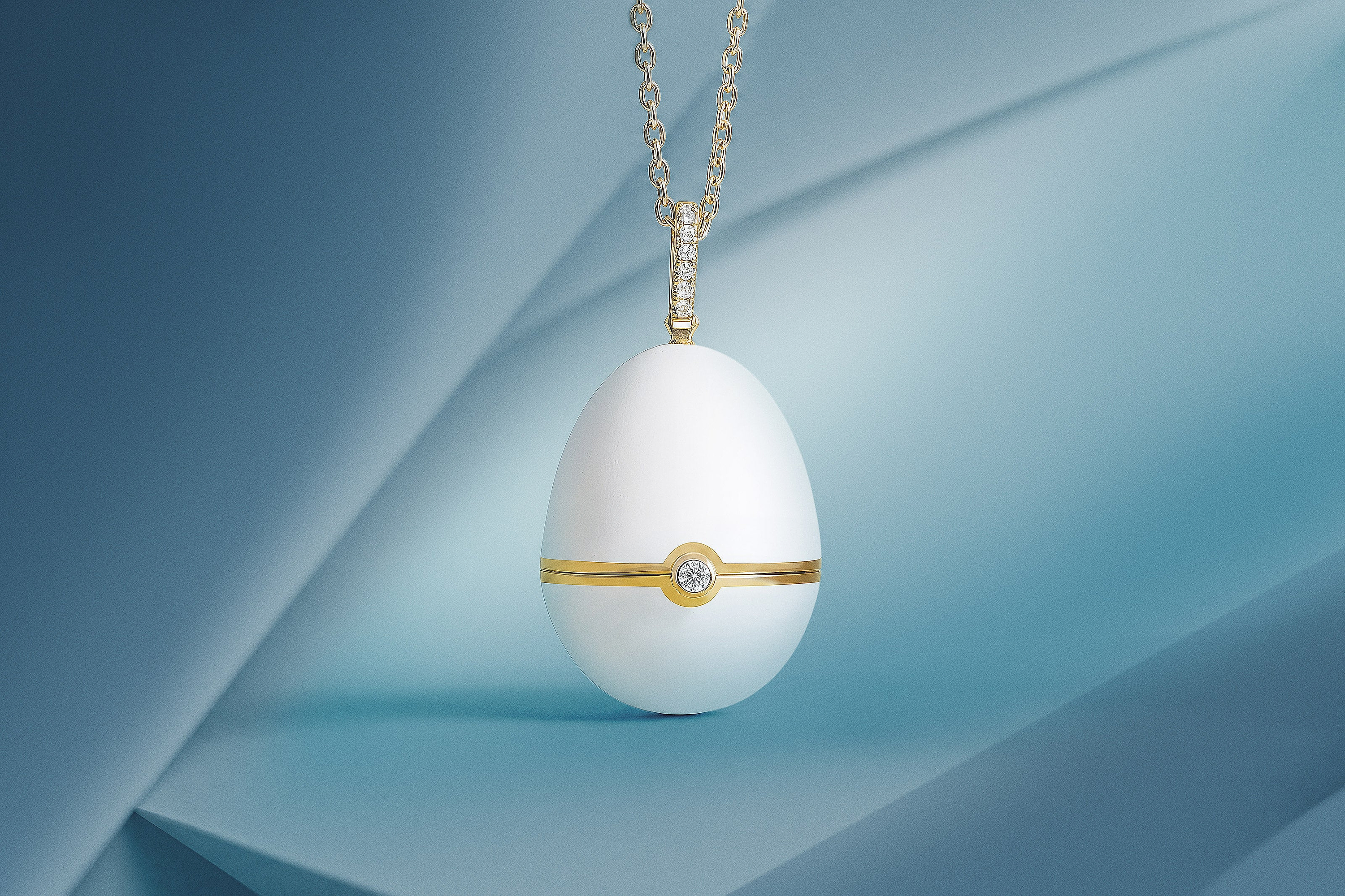 Fabergé №1 Matt White Enamel Egg Pendant Locket in 18 karat yellow gold featuring hand-painted matt white enamel and brilliant-cut diamonds, inspired by the first Imperial Egg of 1885.