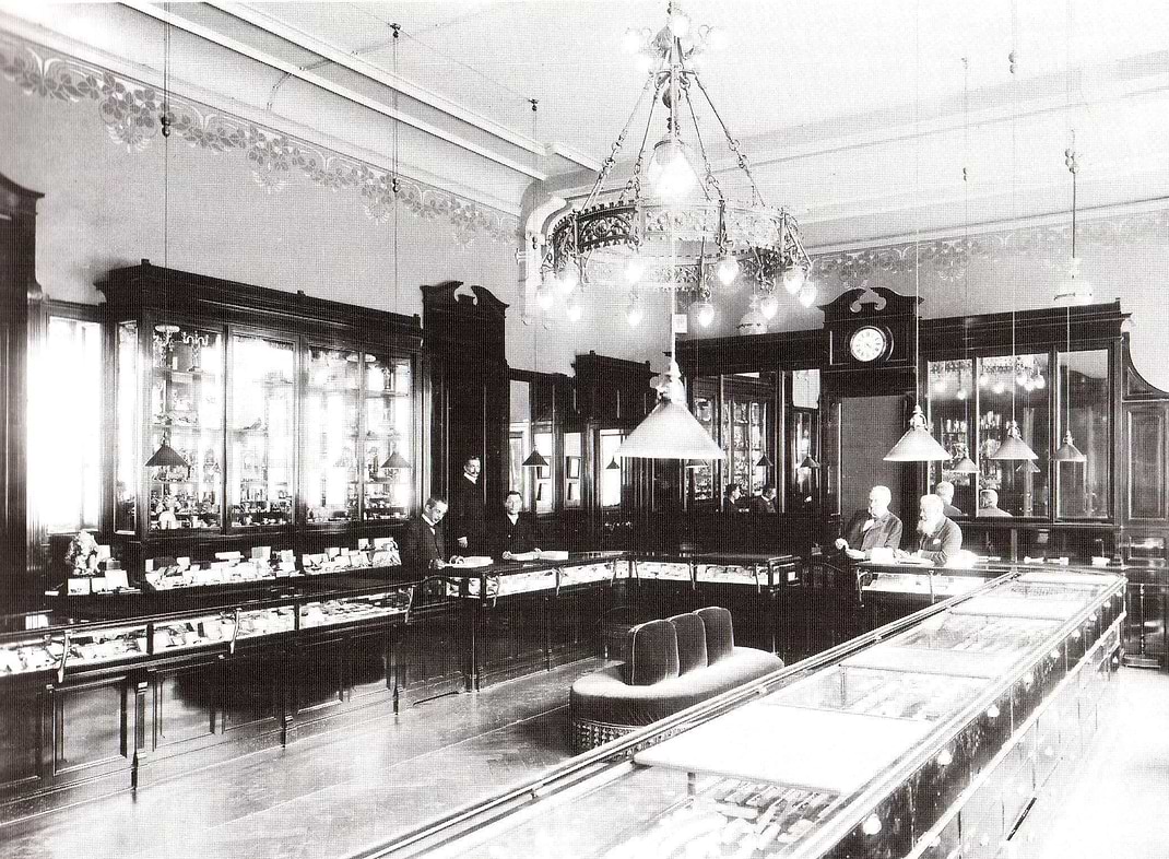 Vintage interior of a jewellery store with glass display cases and chandeliers.