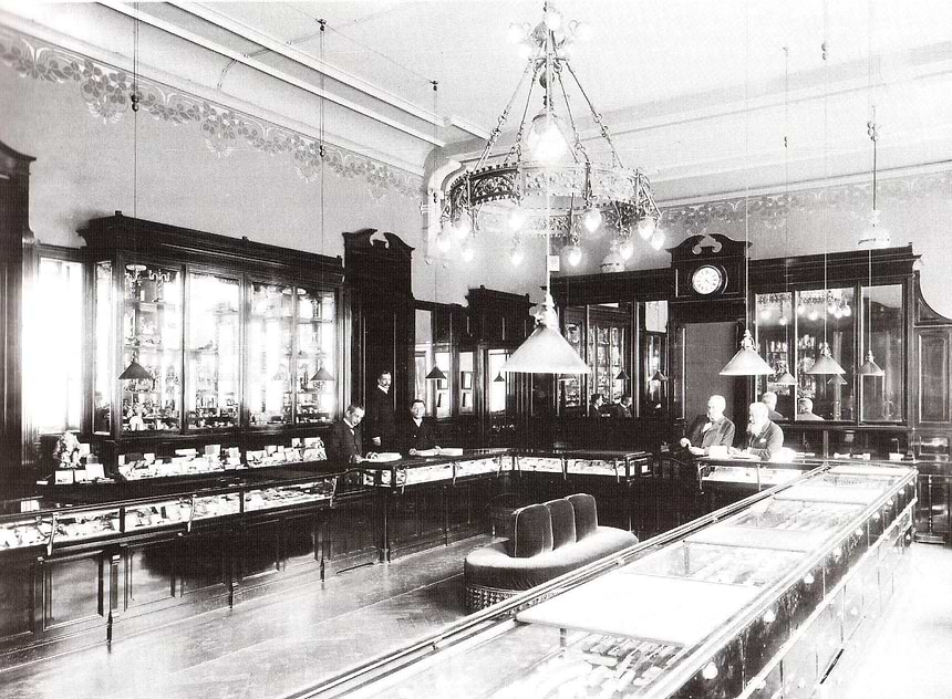 Vintage interior of a jewellery store with glass display cases and chandeliers.