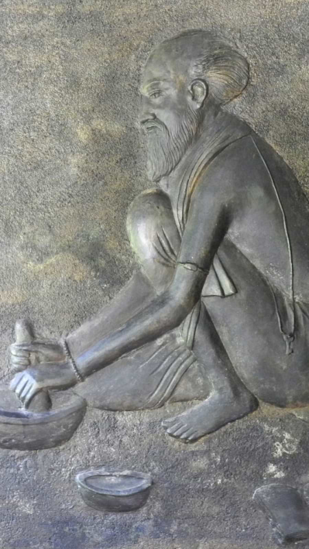 Stone relief carving of an Ayurvedic practitioner