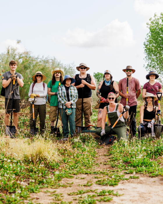 The WishGarden team gathered outdoors with shovels and field gear