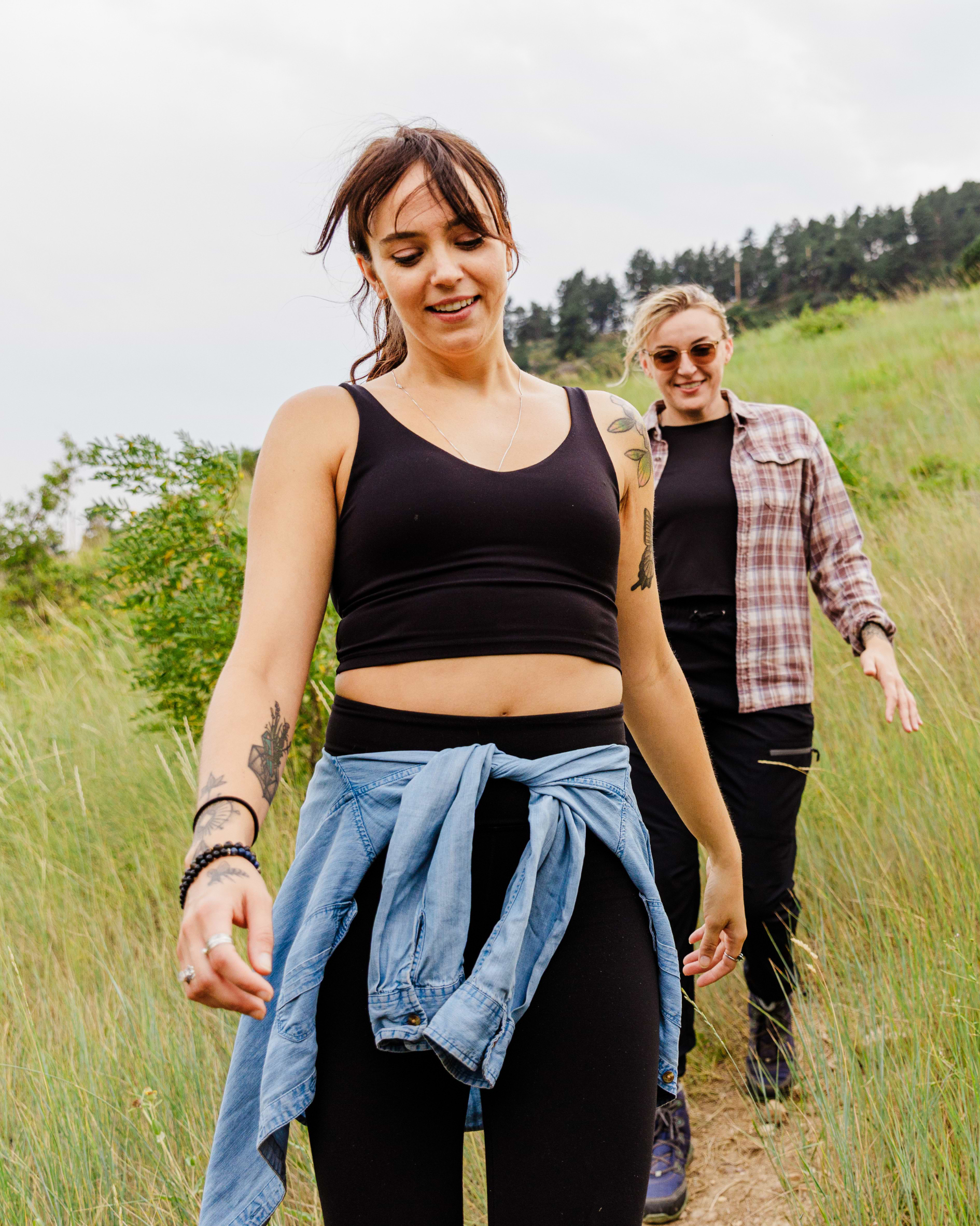 Two women walking on a trail in a natural setting