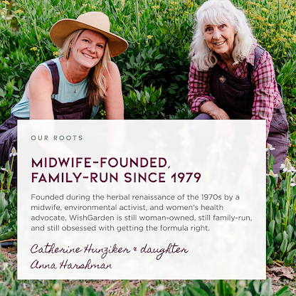 Anna & Catherine from WishGarden smiling in a green garden behind a large white text box with the headline 'OUR ROOTS' and 'MIDWIFE-FOUNDED, FAMILY-RUN SINCE 1979,' plus founder names Catherine Hunziker and Anna Harshman