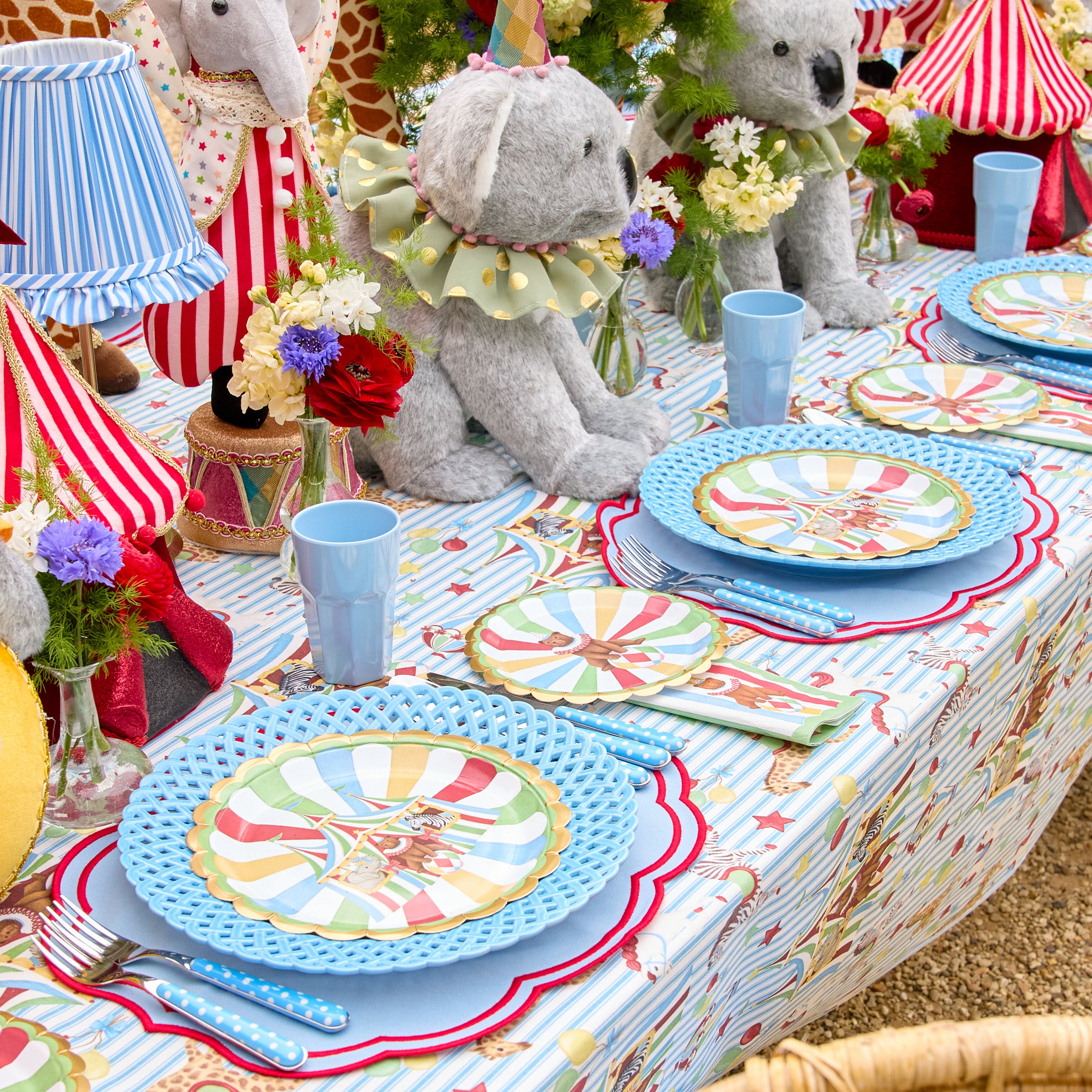 Colorful table setting with teddy bears and decorative plates in a playful, circus-themed arrangement.
