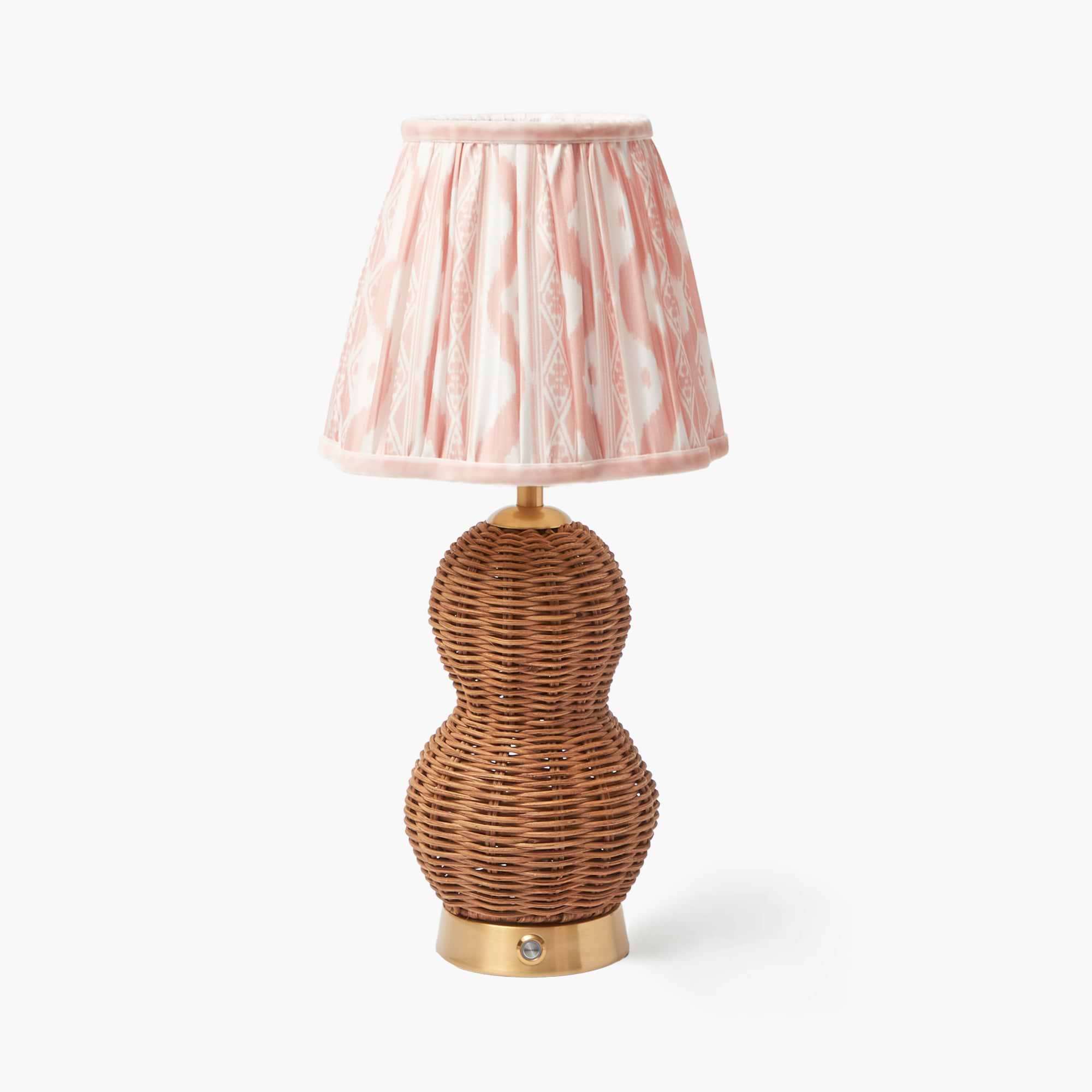 A Rattan Bardot rechargeable lamp with a pink Ikat shade on a white background.