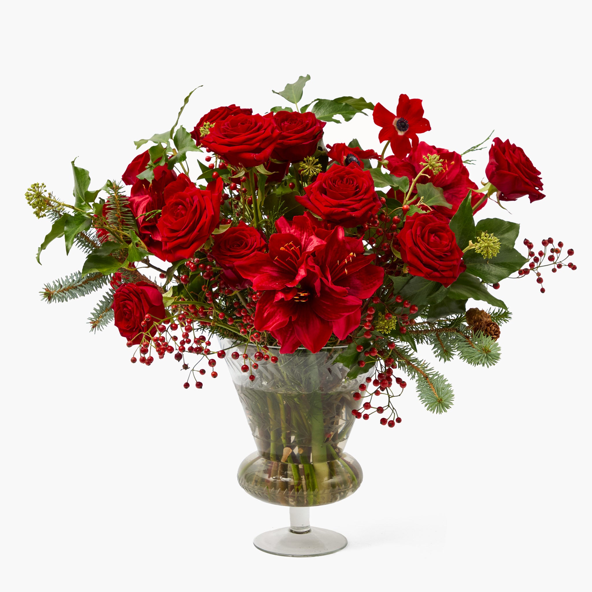 Bouquet of red roses with greenery in a decorative vase on a white background