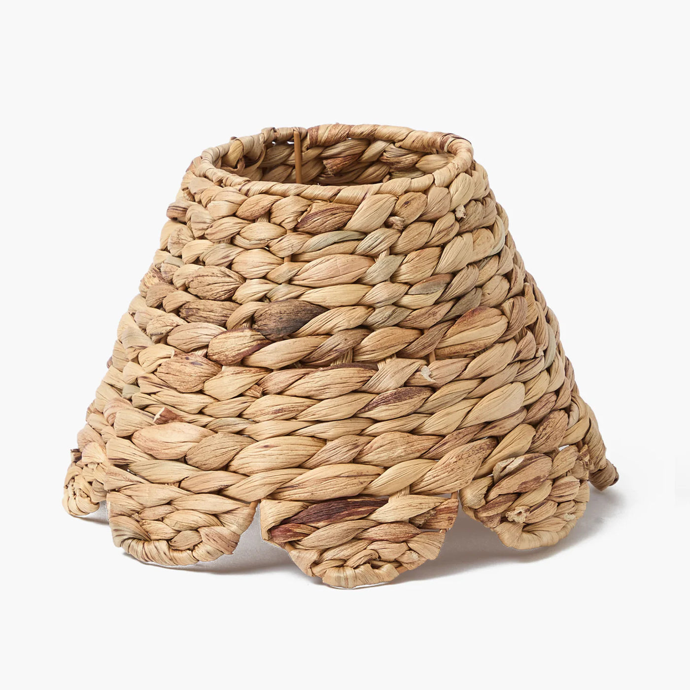 A beige natural seagrass lampshade with a conical shape and open weaved design.
