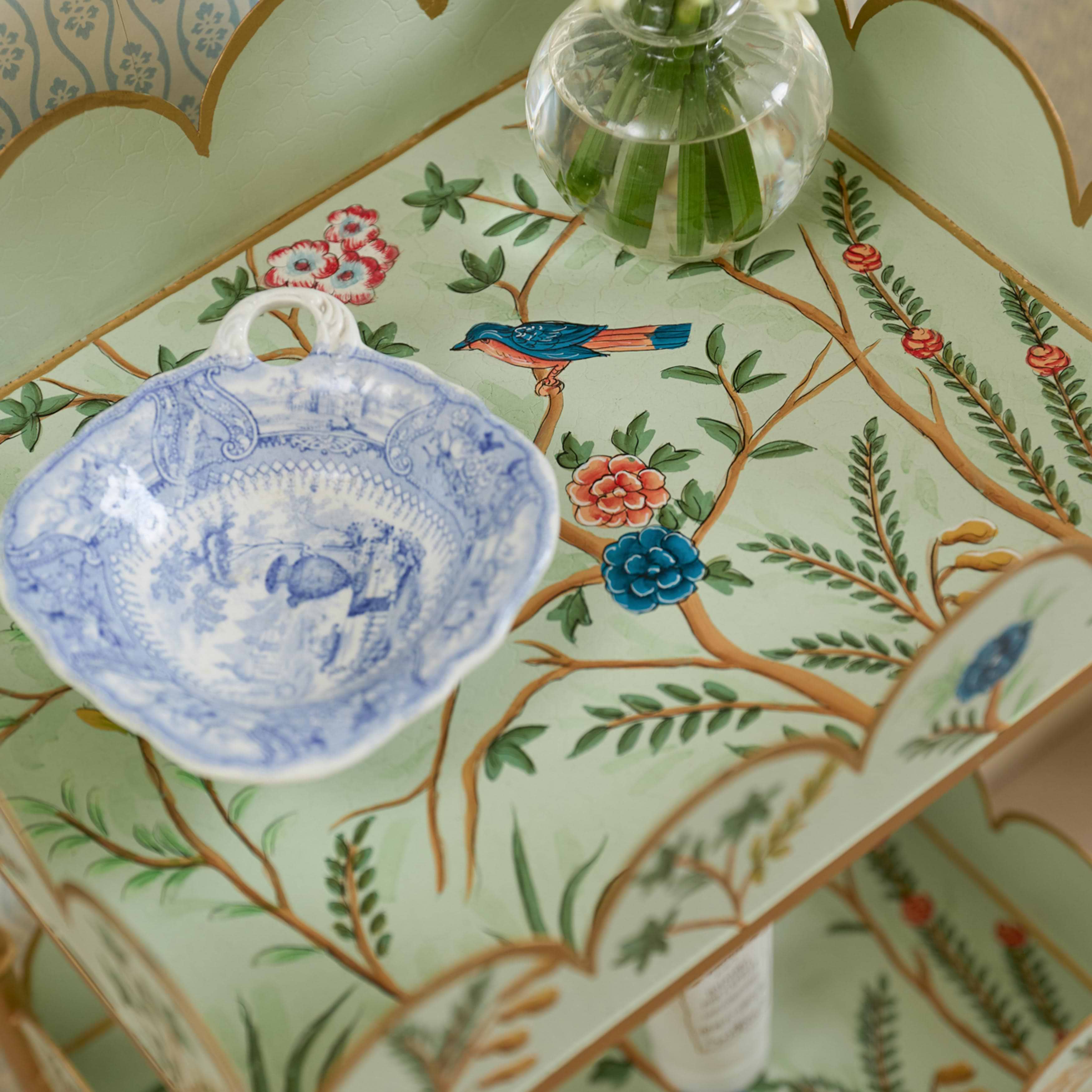 Decorative table with floral patterns and a blue ceramic dish.