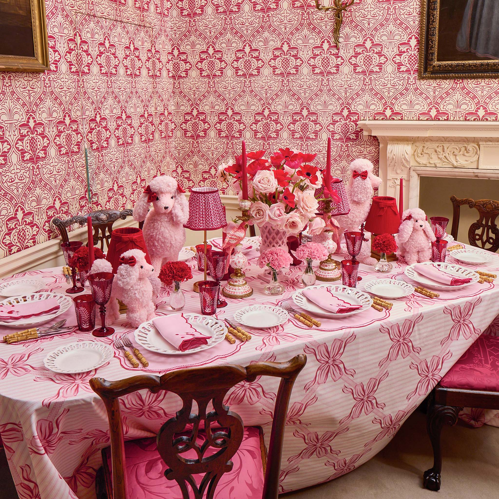 Dining room with a table set for a formal dinner, featuring pink tablecloth and decorative elements.