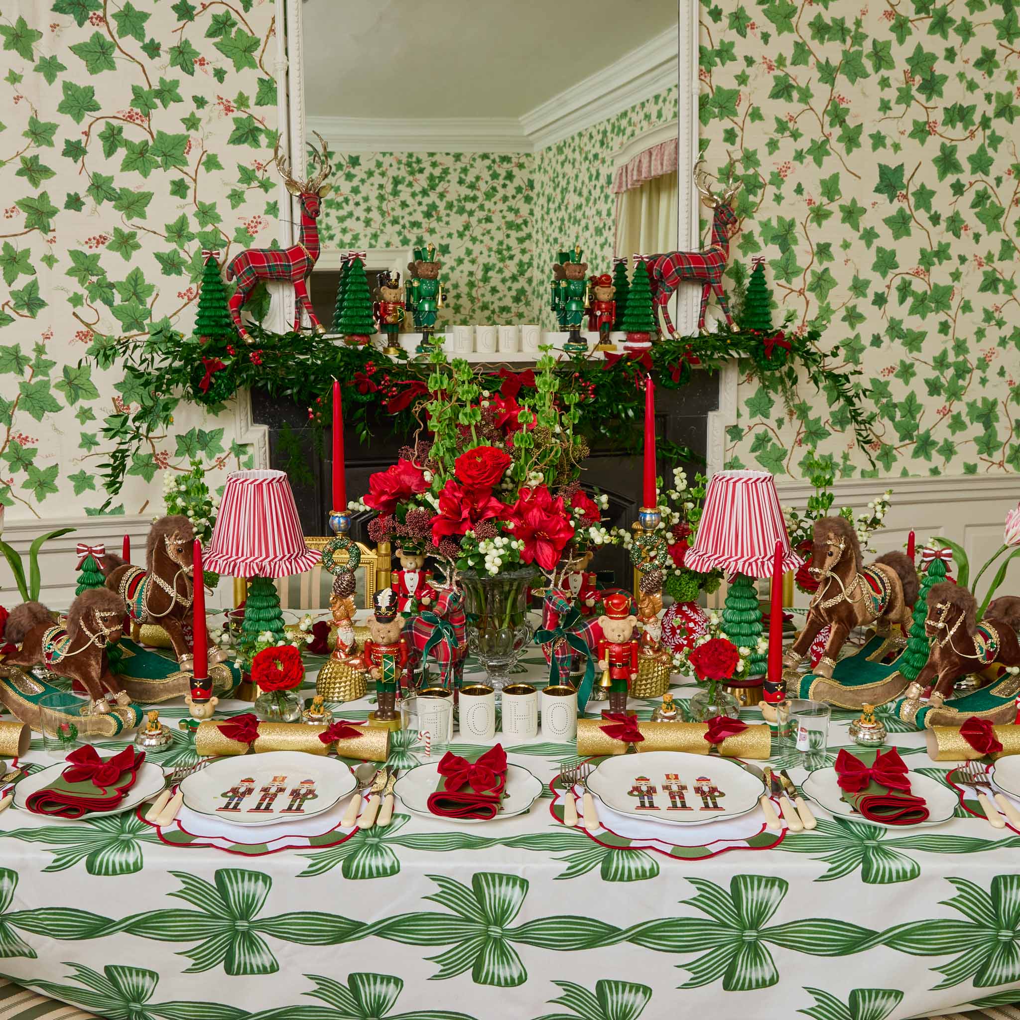 Decorative Christmas table setting with green and red theme, including tablecloth, plates, and centerpieces.