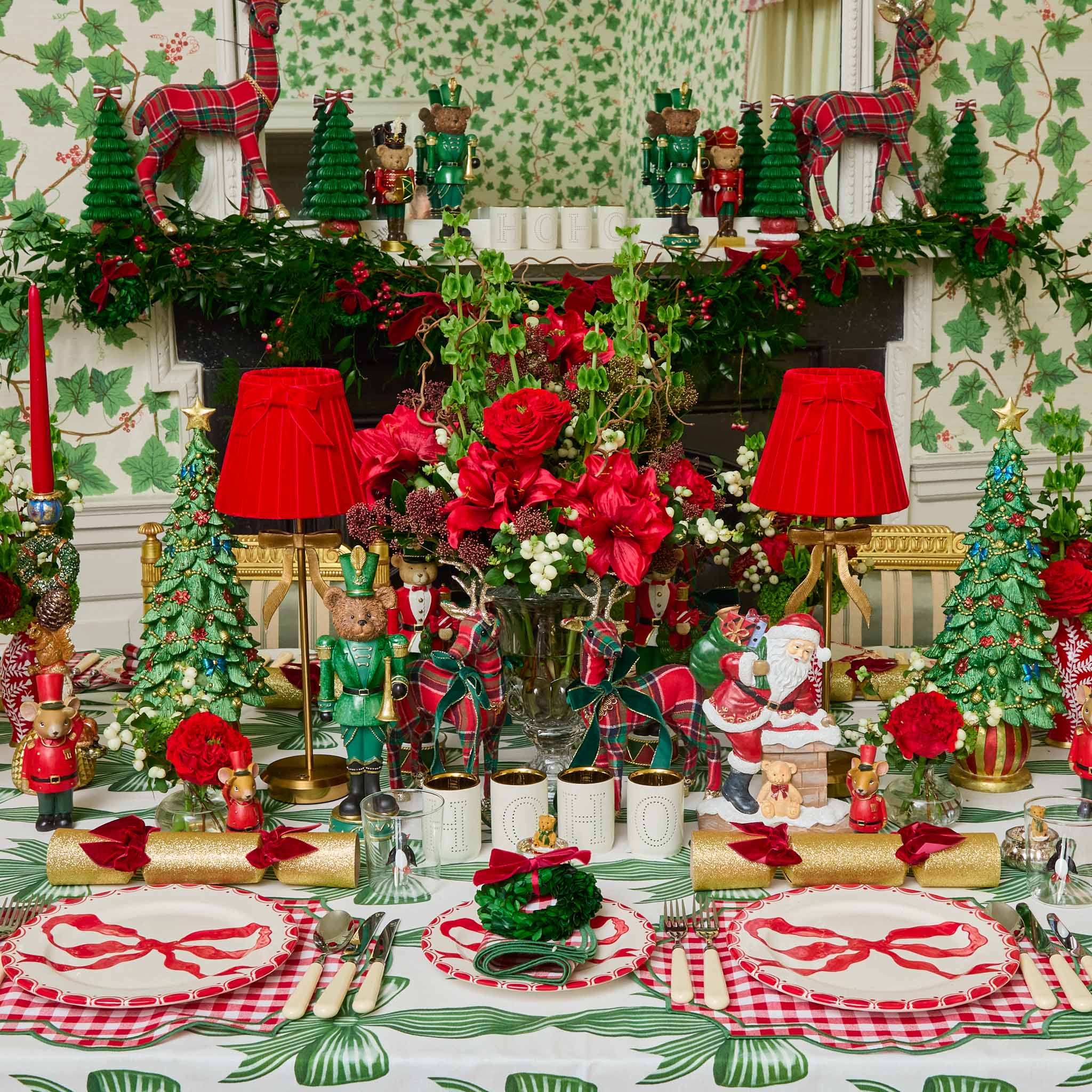 Decorative Christmas table setting with red and green ornaments, candles, and a floral centerpiece.