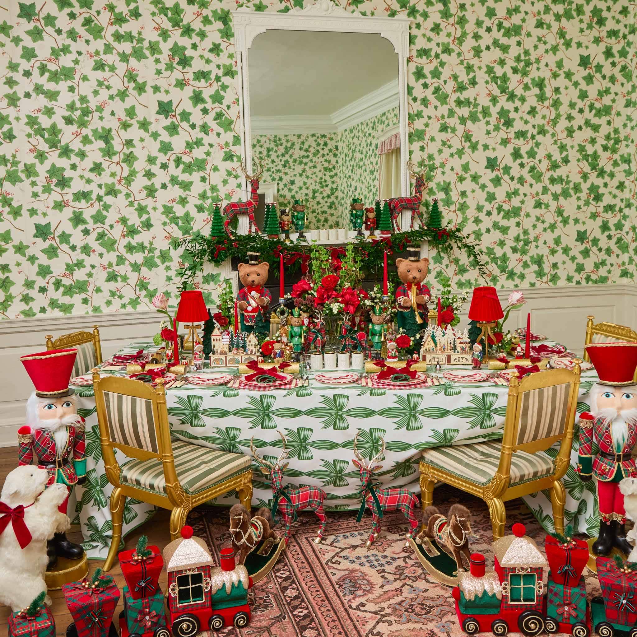 Decorative Christmas table setting with teddy bears, nutcrackers, and a festive tablecloth.