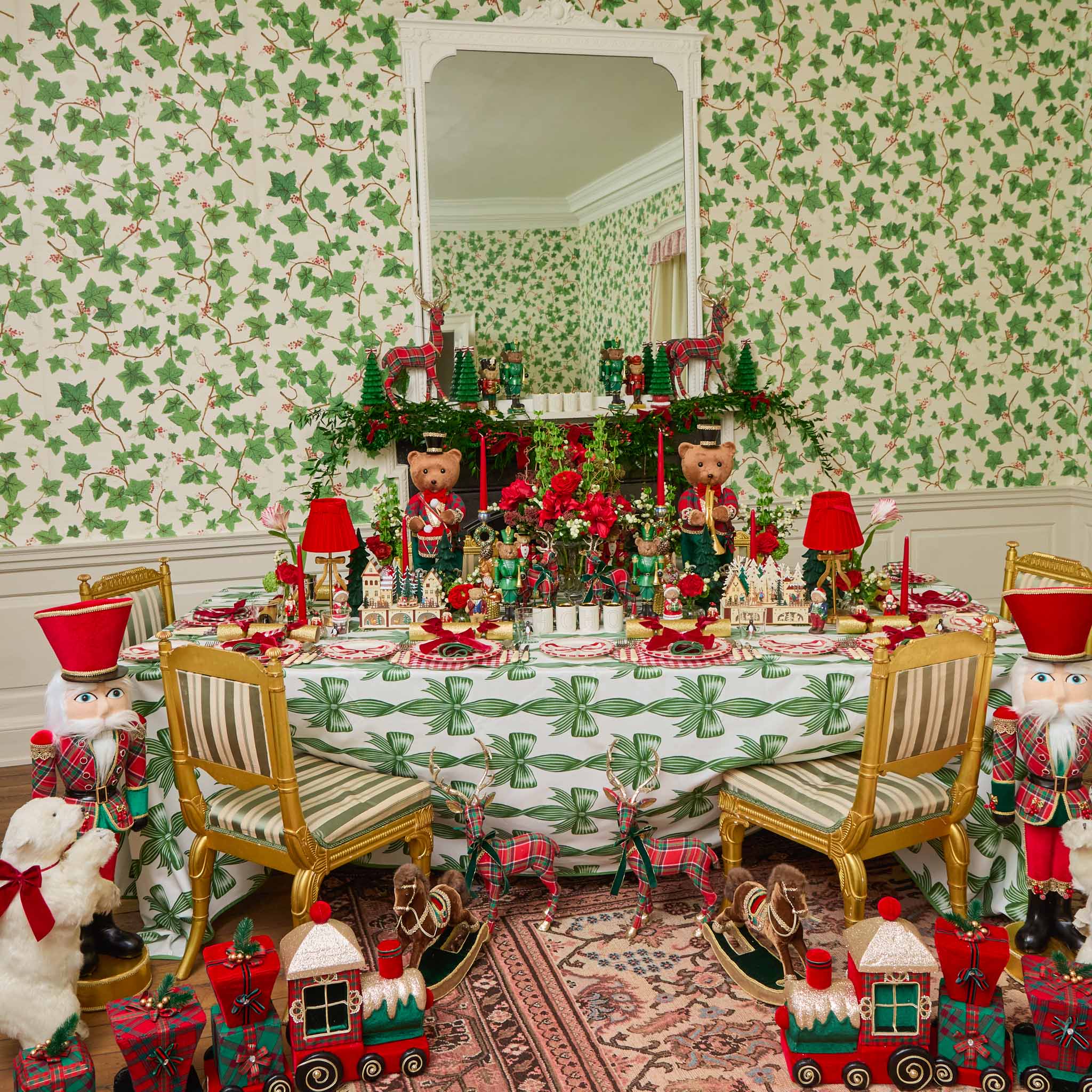 Decorative Christmas table setting with teddy bears, nutcrackers, and a festive tablecloth.