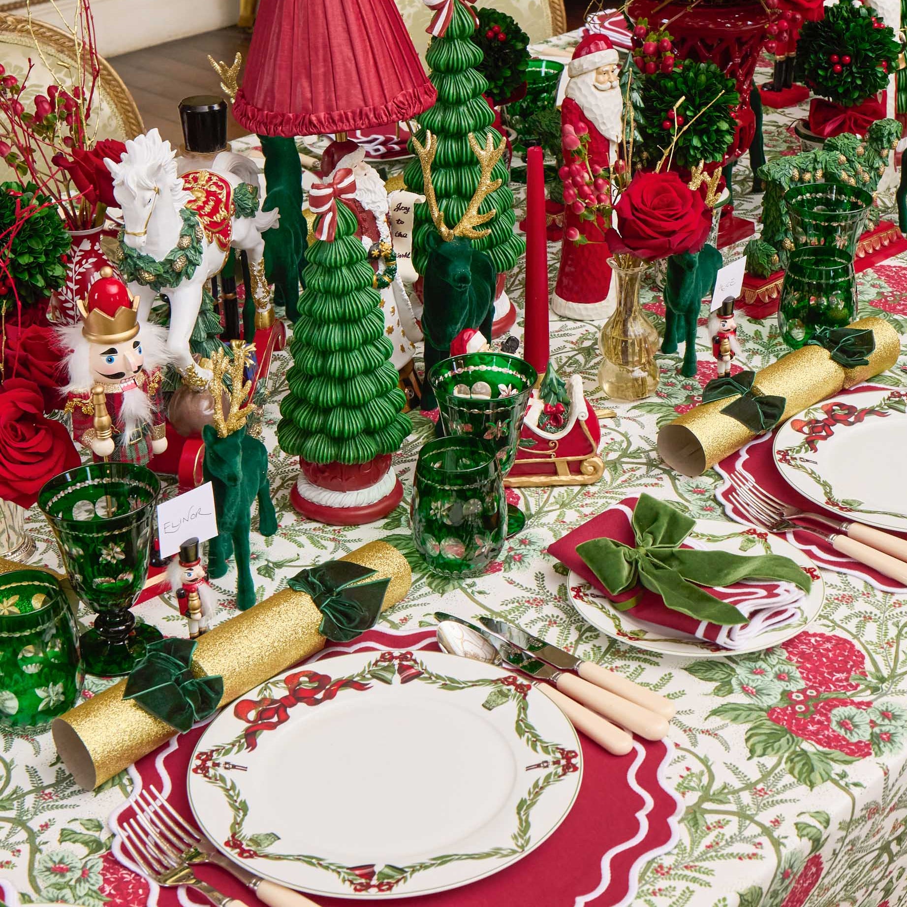 Decorative Christmas table setting with ornaments, plates, and cutlery.