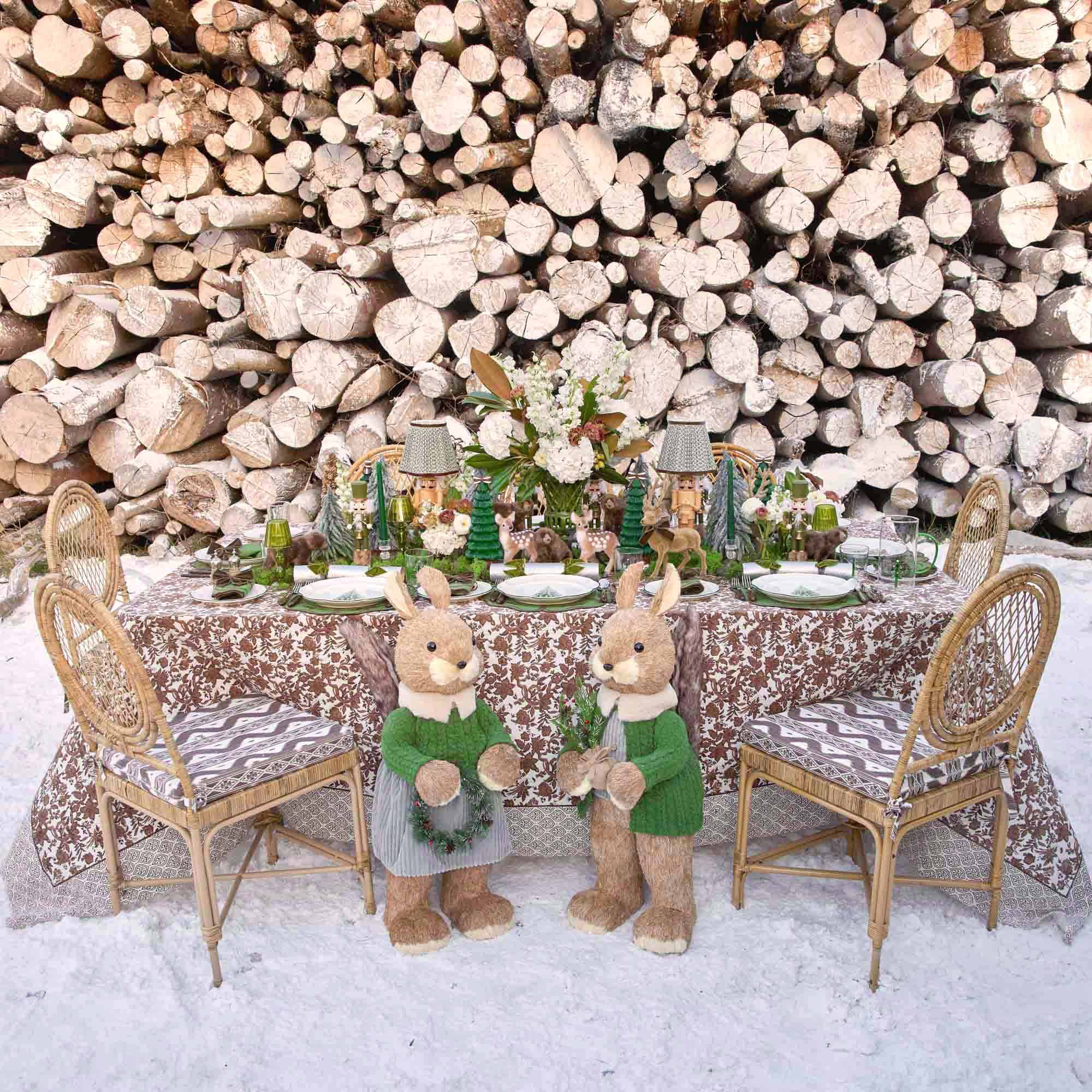 Decorative table setting with squirrel in front of stacked logs