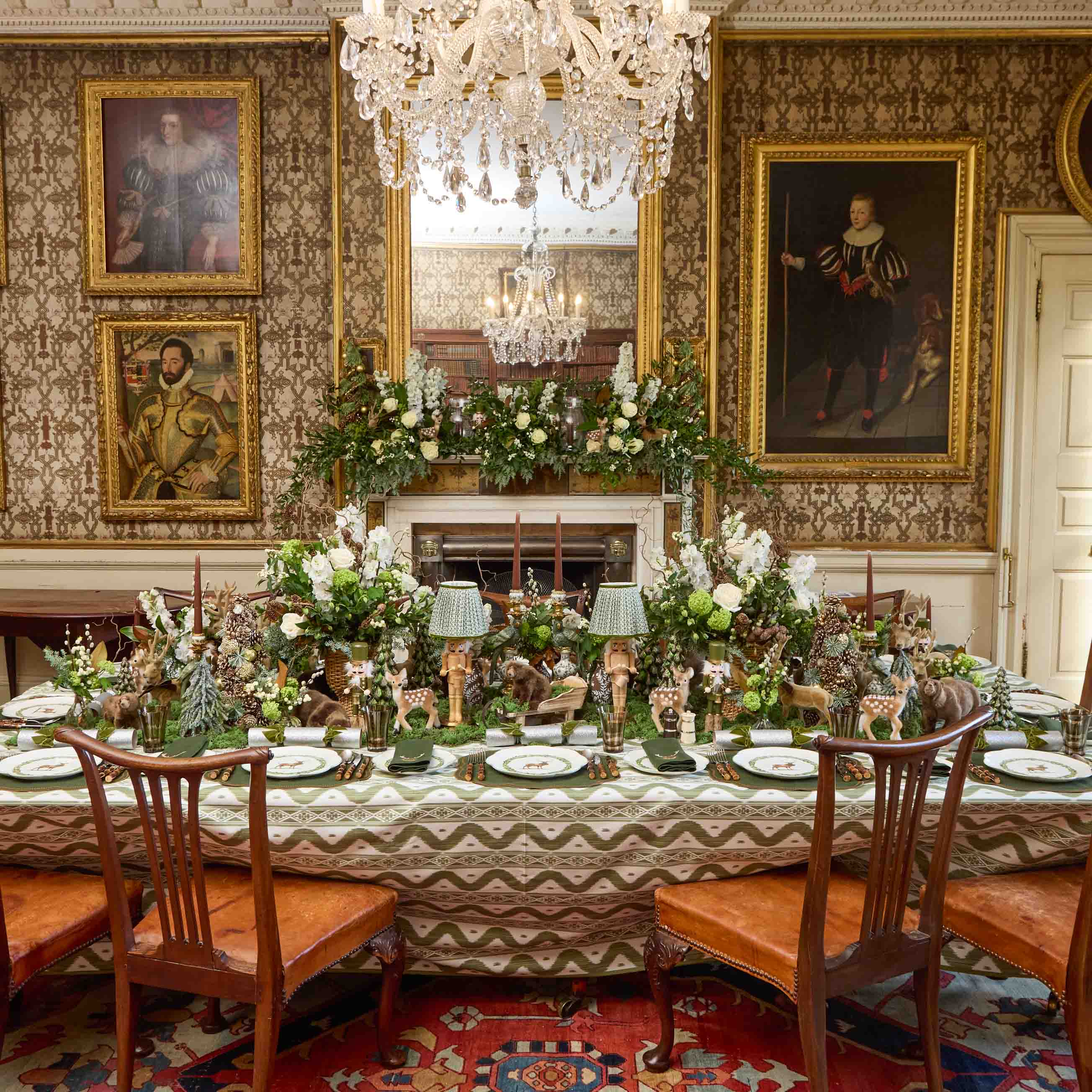 Decorative dining room with a long table set for a meal, ornate chairs, and wall portraits.