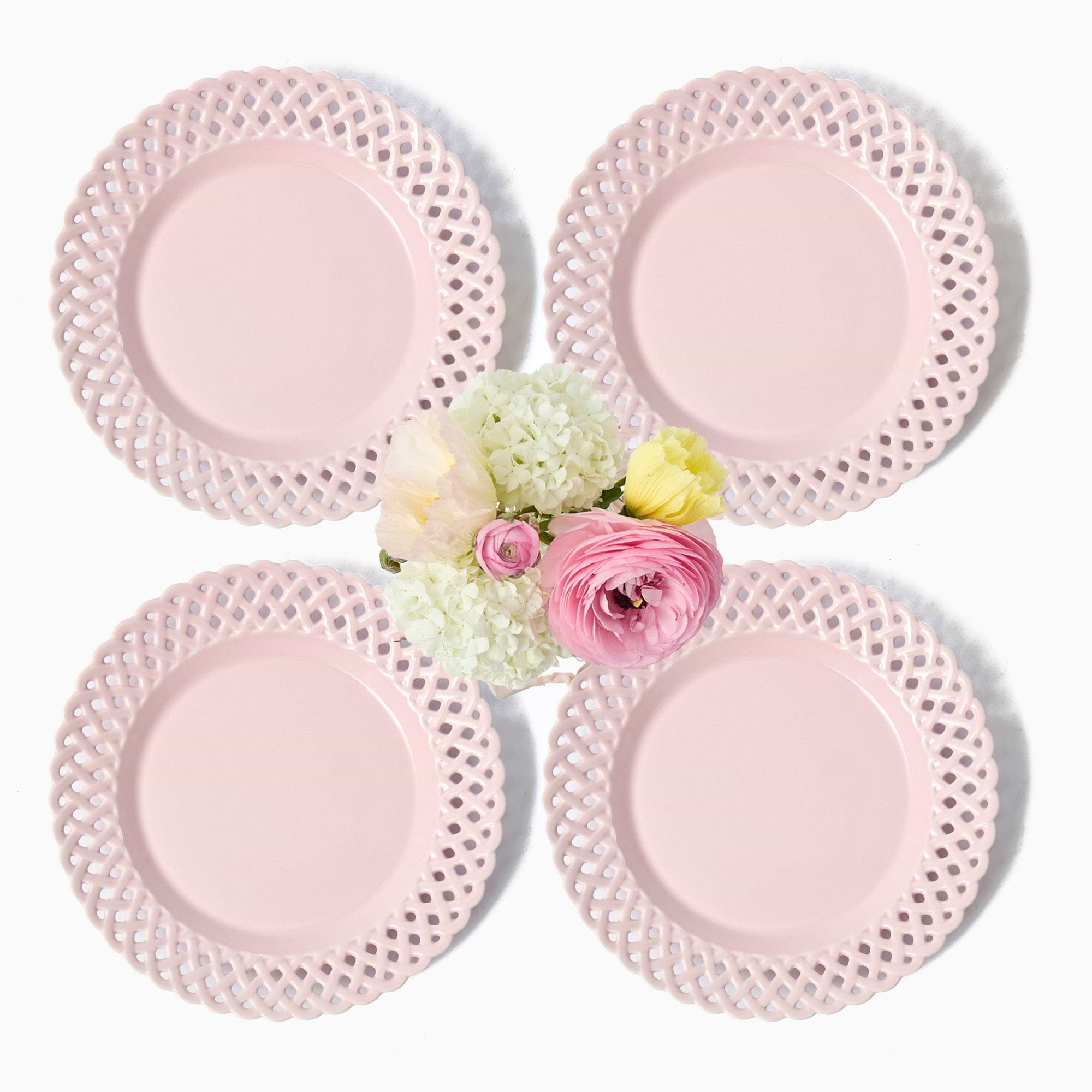 Four pink lace plates with a small bouquet of red and white roses in the center on a white background.