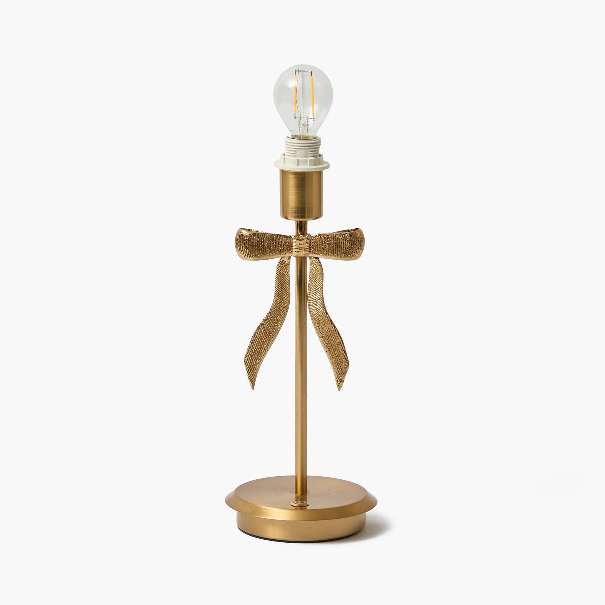 Gold table lamp with a decorative bow on a white background