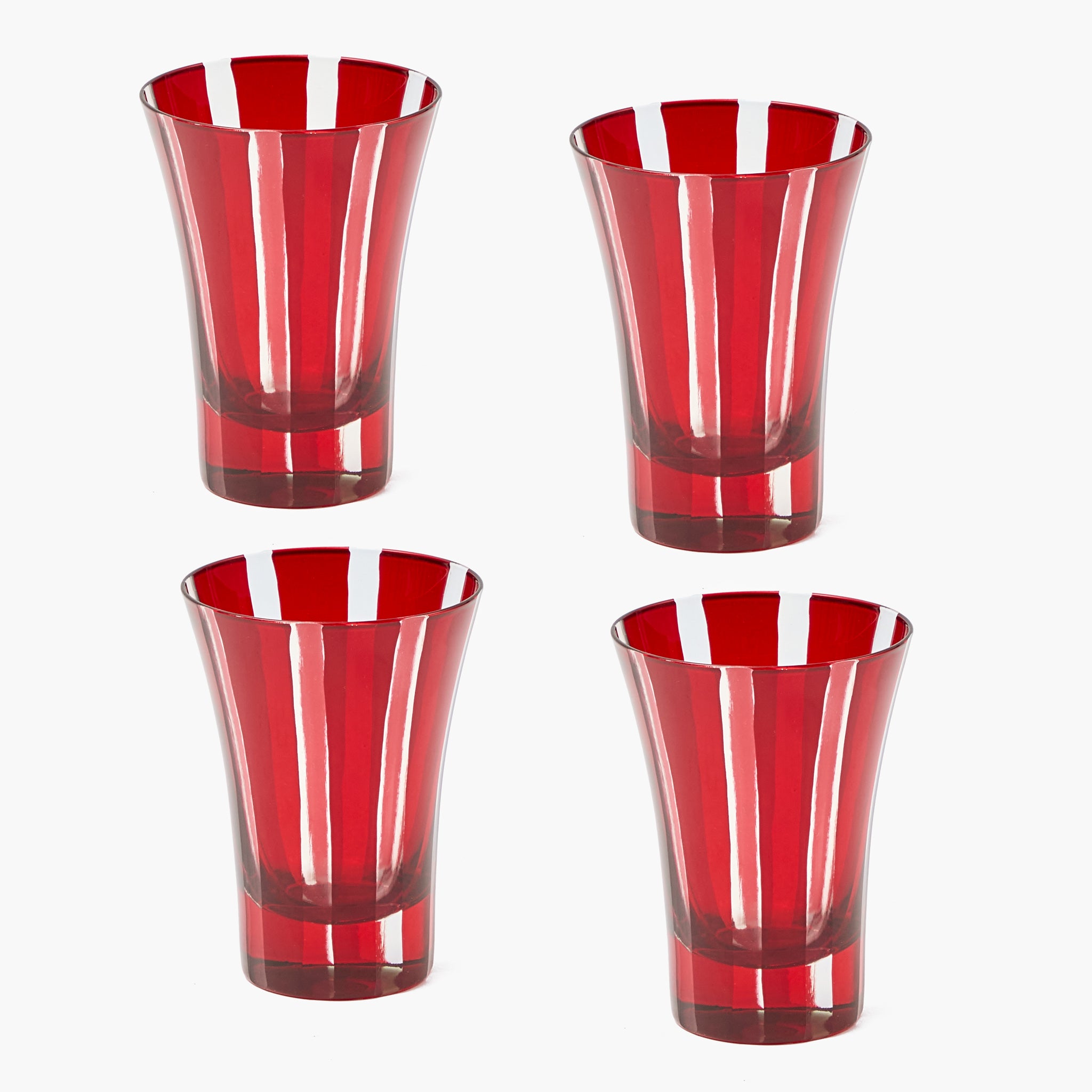 Four red glass tumblers with white stripes on a white background