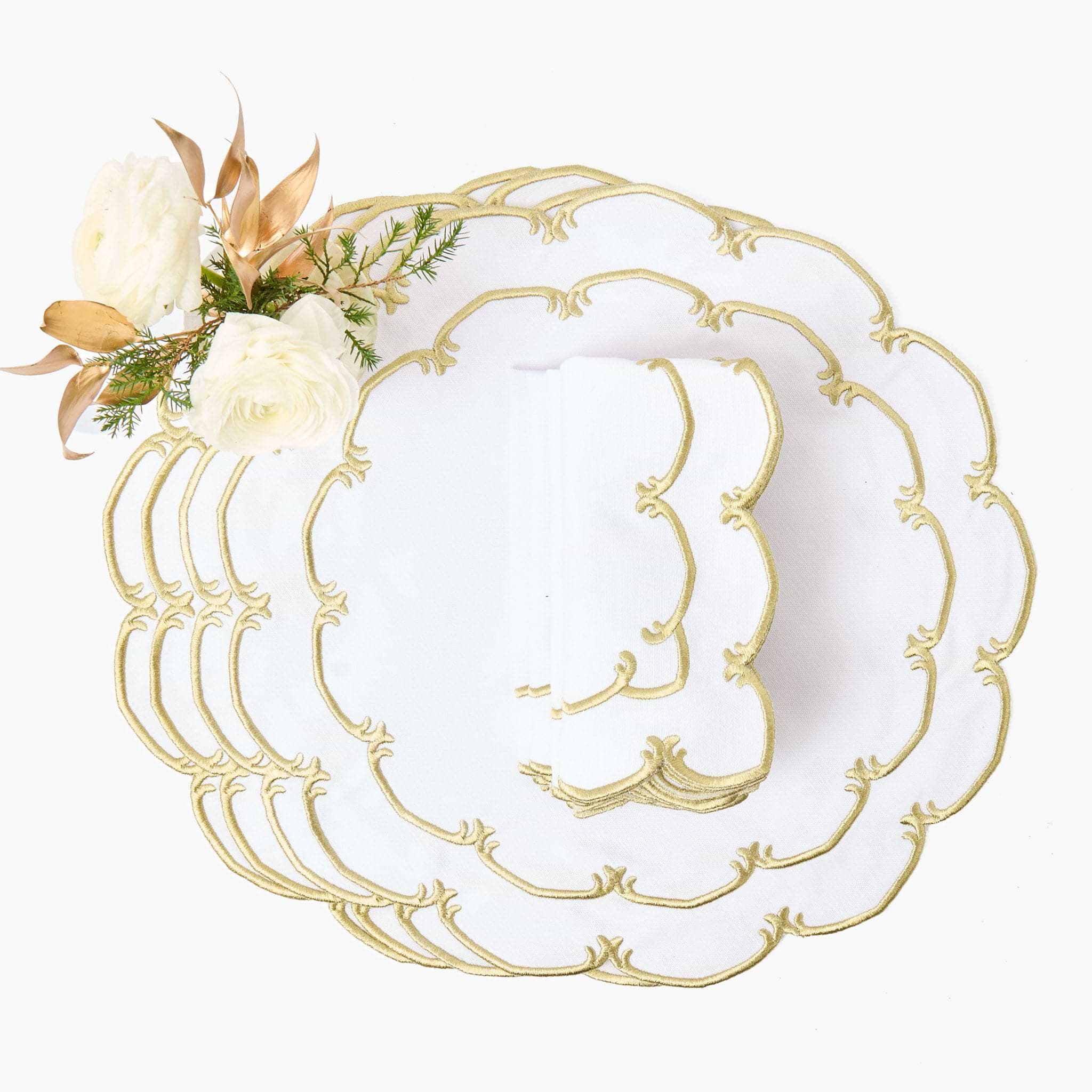 Set of white plates with gold decorative edge on a white background