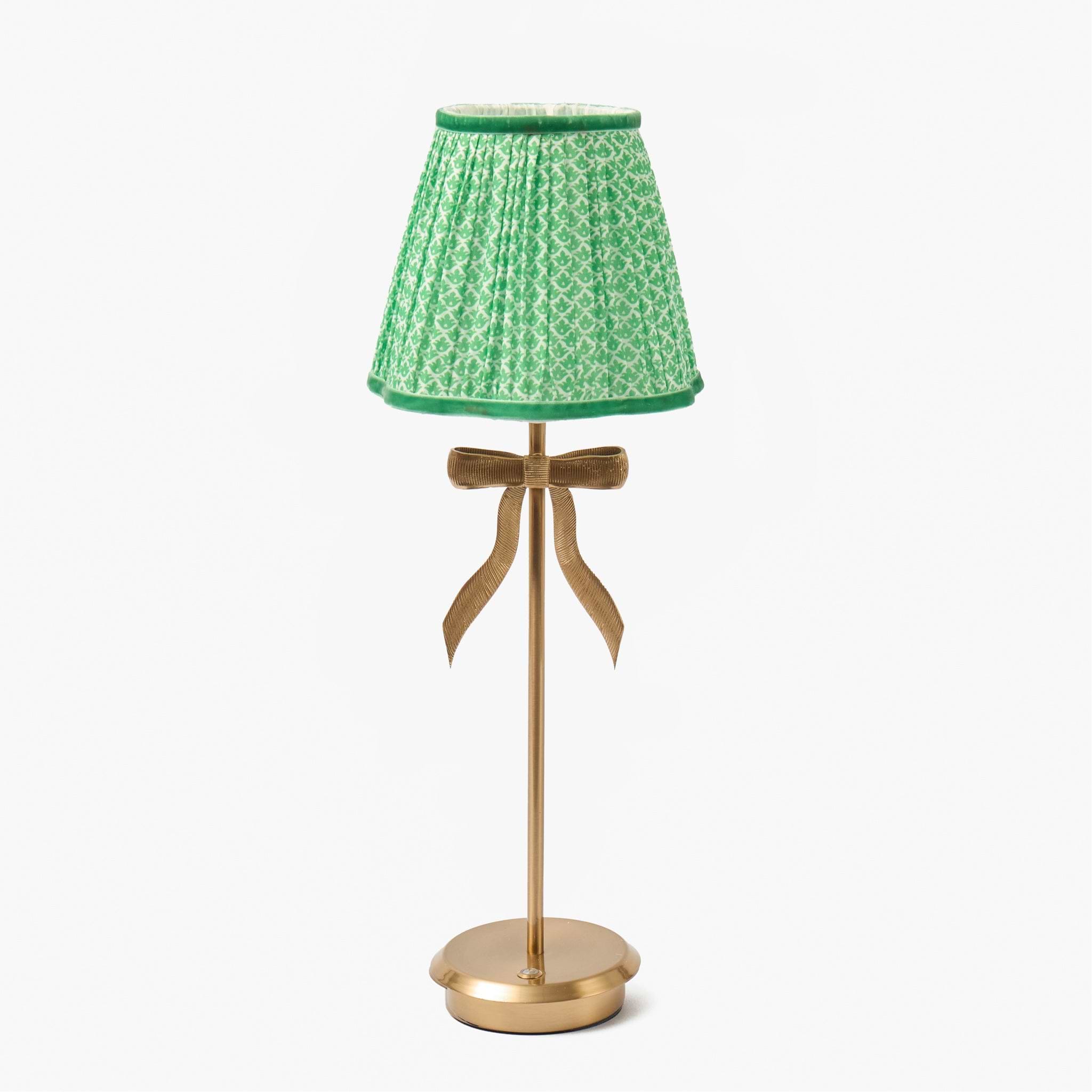 Small lamp with a green patterned shade and gold base on a white background