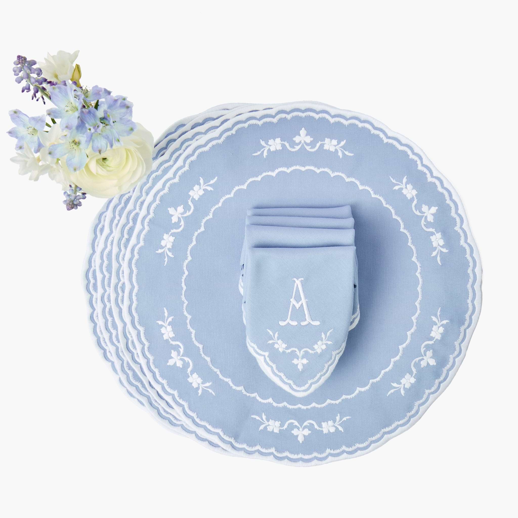 Light blue place setting with floral arrangement on a white background